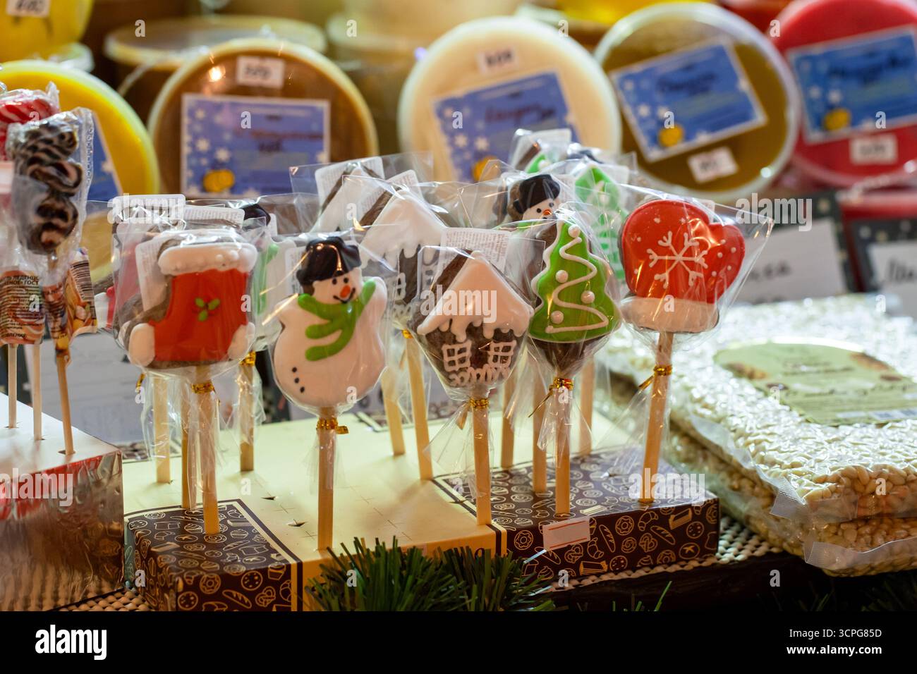 Vivaci prelibatezze natalizie su bastoncini, tra cui pupazzo di neve, albero di natale e biscotti della casa avvolti in borse trasparenti, colori brillanti e decorazioni natalizie a mar Foto Stock