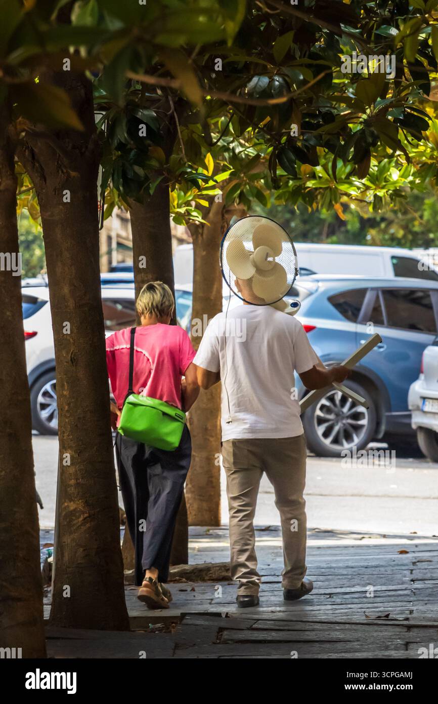 Ondata di caldo a Roma, l'uomo porta un fan sulla spalla in città, Roma, Italia 07-14-2025 Foto Stock