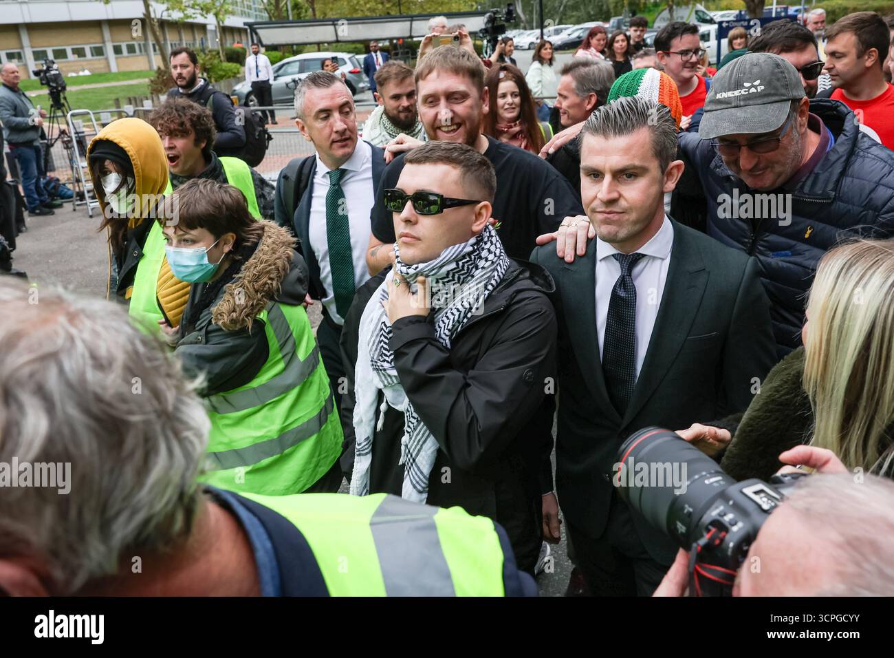 LONDRA, Regno Unito - 26 settembre 2025: Liam Óg Ó hAnnaidh, noto anche come Mo Chara del gruppo rap Kneecap, lascia la corte di Woolwich a Londra dopo che un giudice ha respinto le accuse di terrorismo contro di lui. Mo Chara era stato accusato di aver esposto una bandiera Hezbollah ad un concerto, un'accusa che ha negato, ma il caso è stato respinto. I sostenitori di Kneecap hanno accolto con favore la decisione fuori dal tribunale. Crediti: Pete Speller/Alamy Live News Foto Stock