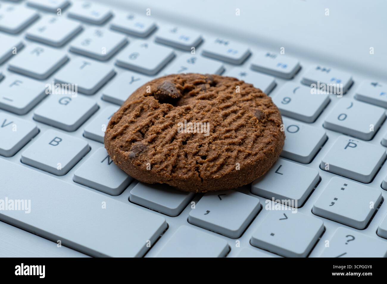 Primo piano di un cookie sulla tastiera di un computer. Cookie Internet, tecnologia e concetti di privacy online. Foto Stock
