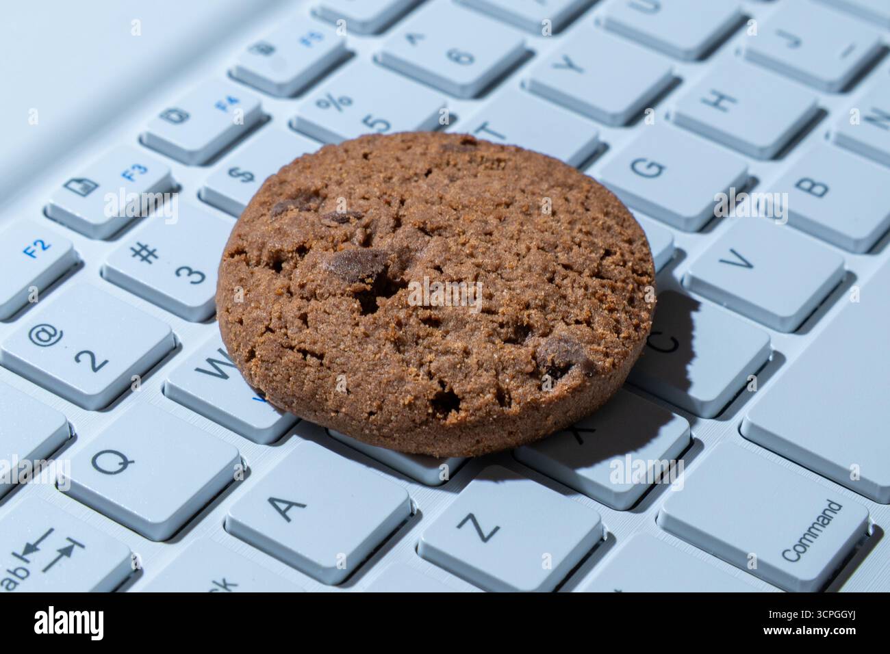 Primo piano di un cookie sulla tastiera di un computer. Cookie Internet, tecnologia e concetti di privacy online. Foto Stock