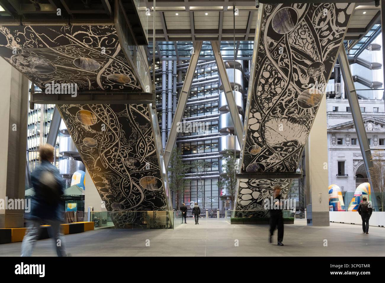 Le persone passano accanto alle installazioni artistiche del Leadenhall Building di Londra, mostrando design moderno e vita urbana. Foto Stock