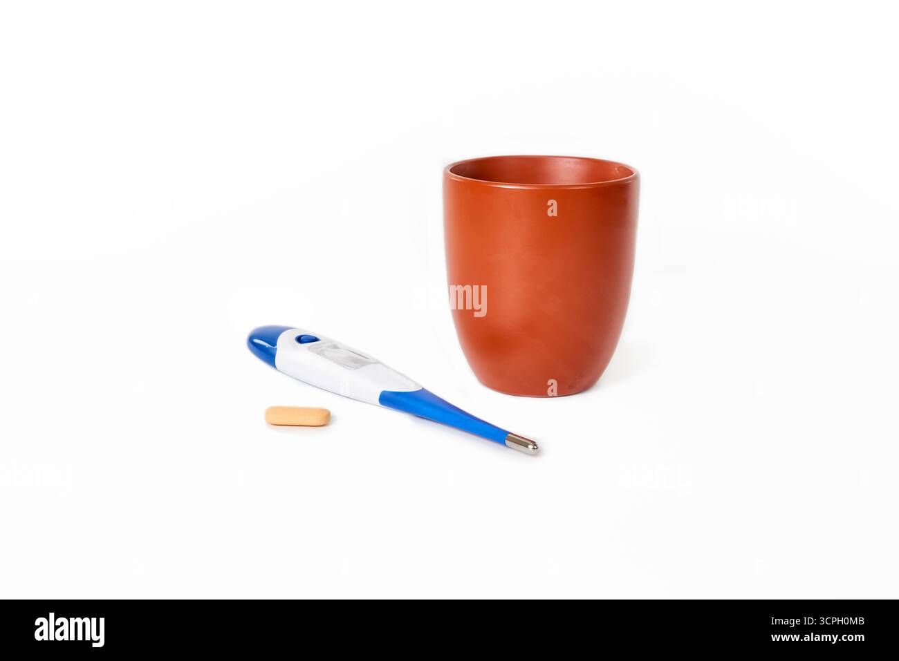 Una natura morta di elementi essenziali per il trattamento di febbre o malattia: Un termometro, farmaci e una tazza per bere. Un concetto per l'assistenza sanitaria, la malattia, un Foto Stock