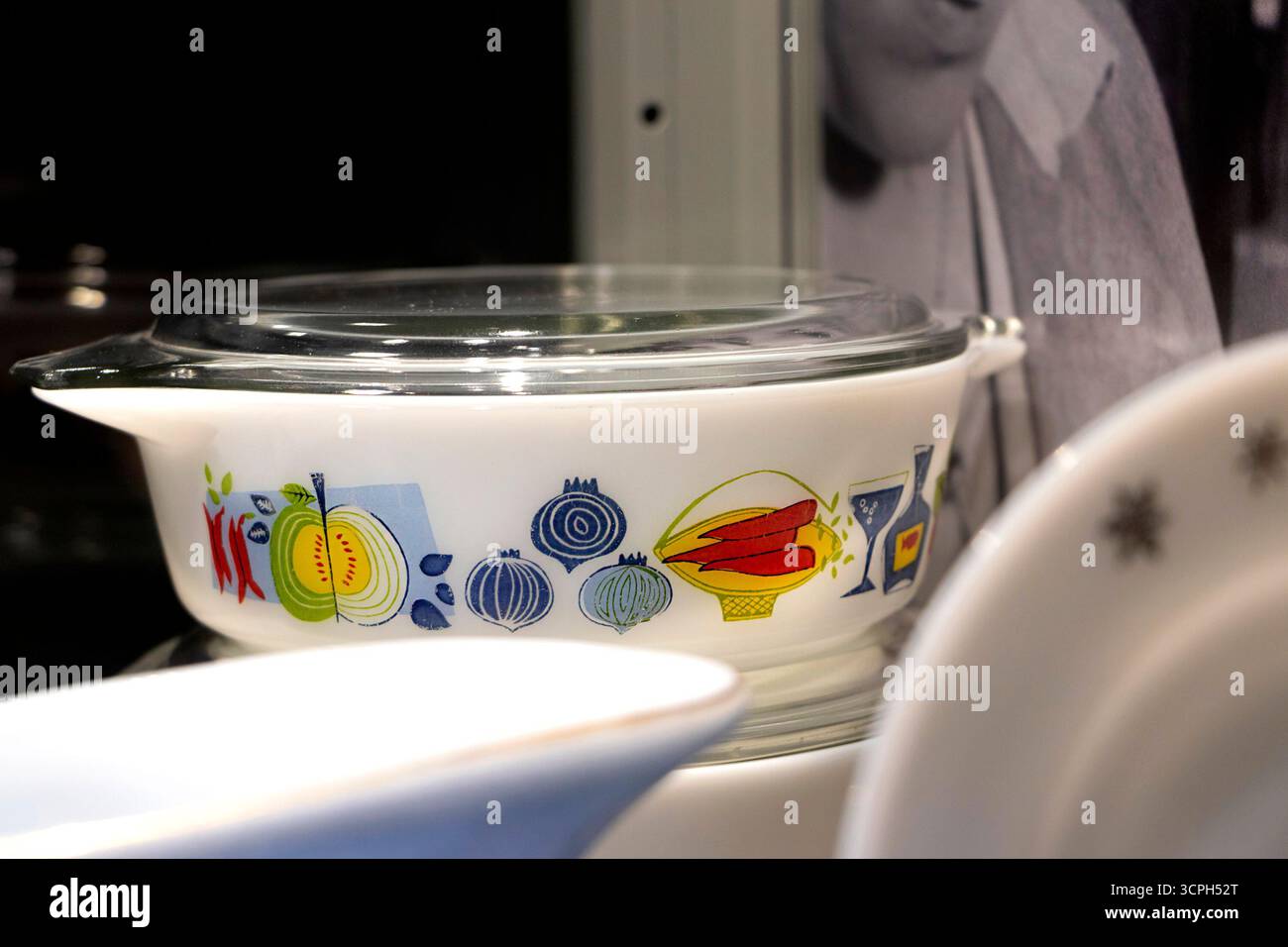 Casseruola Pyrex JAJ fiesta d'epoca con frutta e verdura colorate in un ambiente di cucina dietro un primo piano sfocato Foto Stock