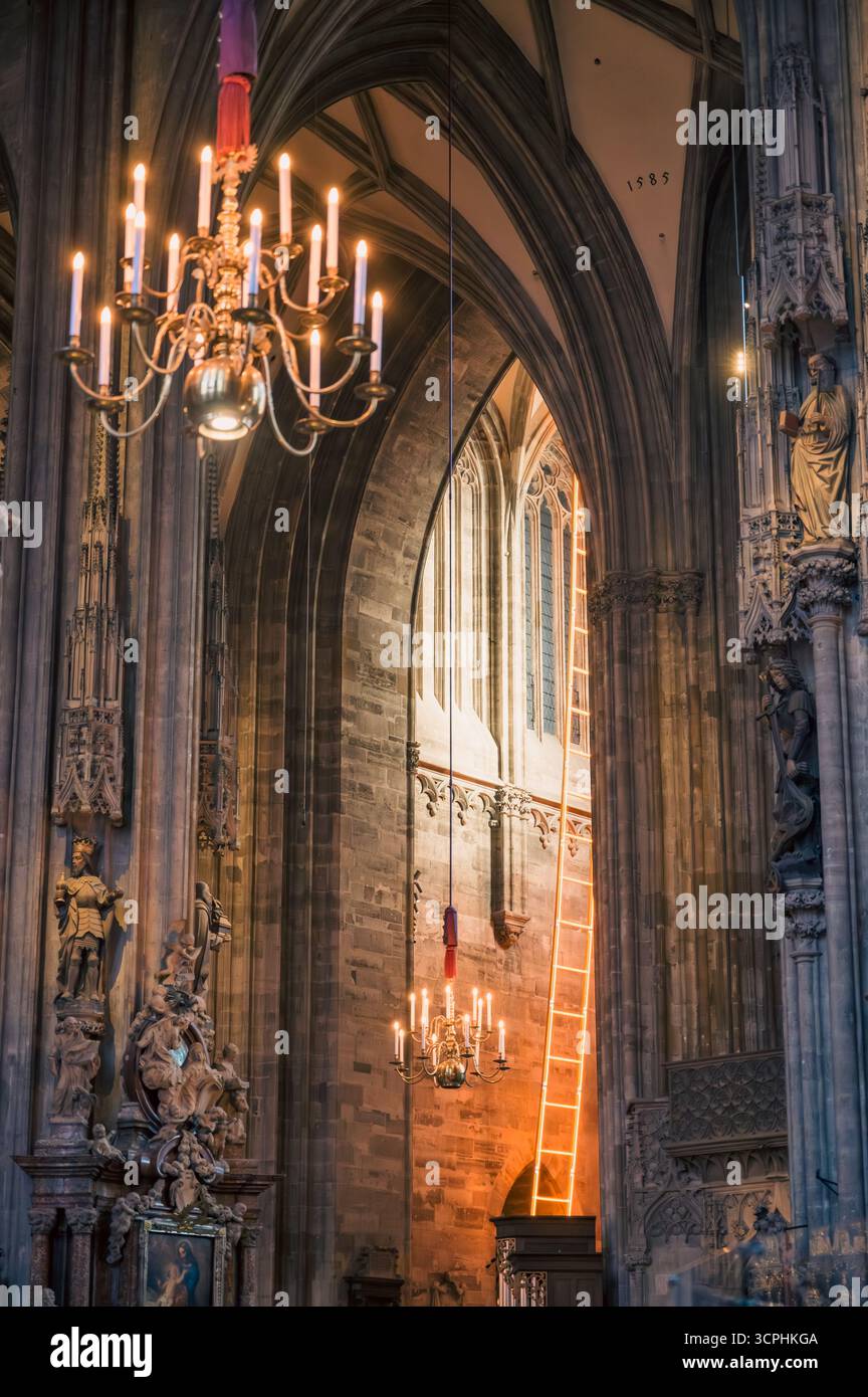 Vienna, Austria - 4 giugno 2022: La cattedrale di Santo Stefano presenta un grande lampadario che illumina intricate sculture in pietra archi maestosi e colorfu Foto Stock