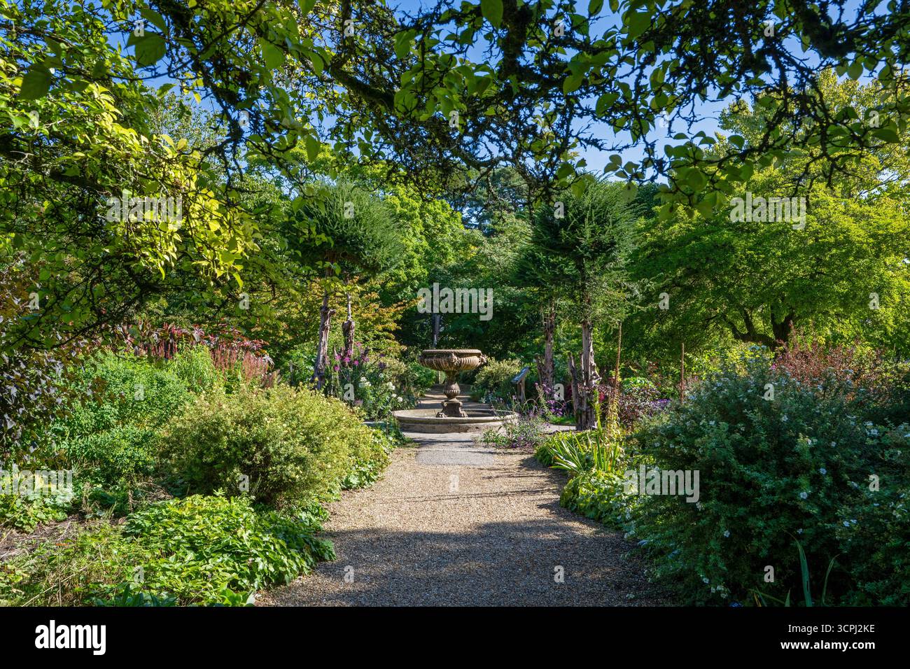 Vista verso la fontana italiana di marmo rosso di Verona tra i doppi confini del Wall Garden a Nymans, West Sussex, Inghilterra, Regno Unito. Foto Stock