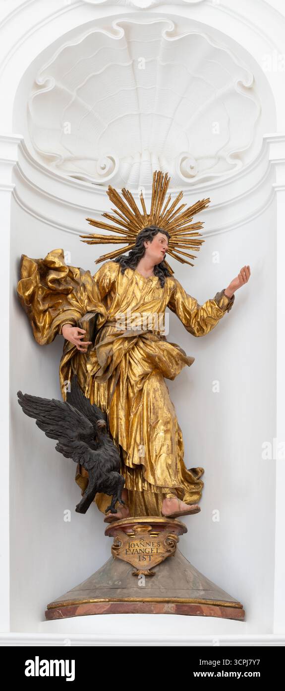SALISBURGO, AUSTIRA - 8 SETTEMBRE 2025: Statua barocca policroma scolpita di San Giovanni Evangelista nella chiesa Kollegienkirche Foto Stock