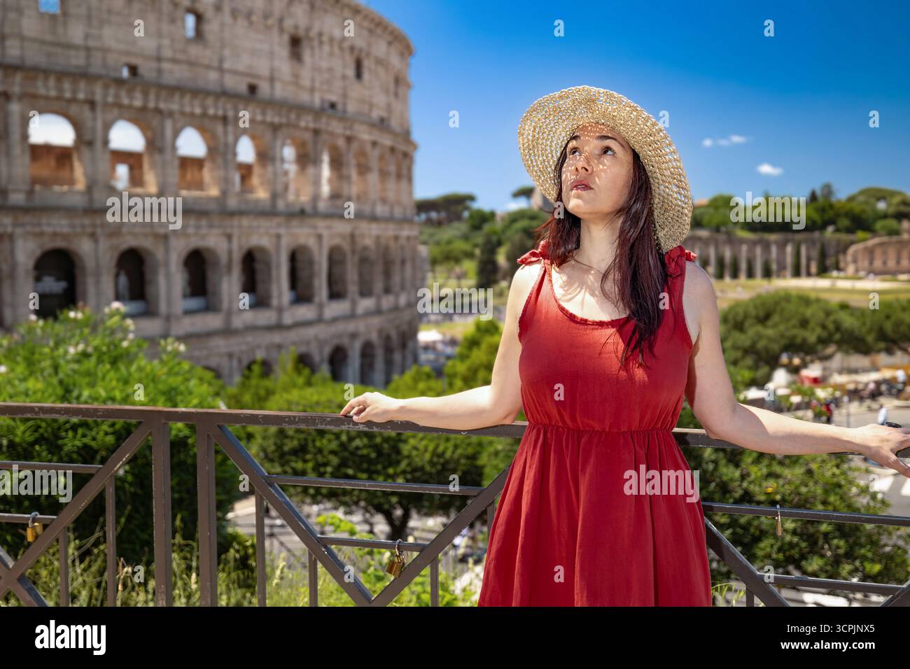 Una ragazza che indossa un cappello è in visita a Roma, in Italia. Sullo sfondo si gode una vista panoramica del Colosseo. Foto Stock