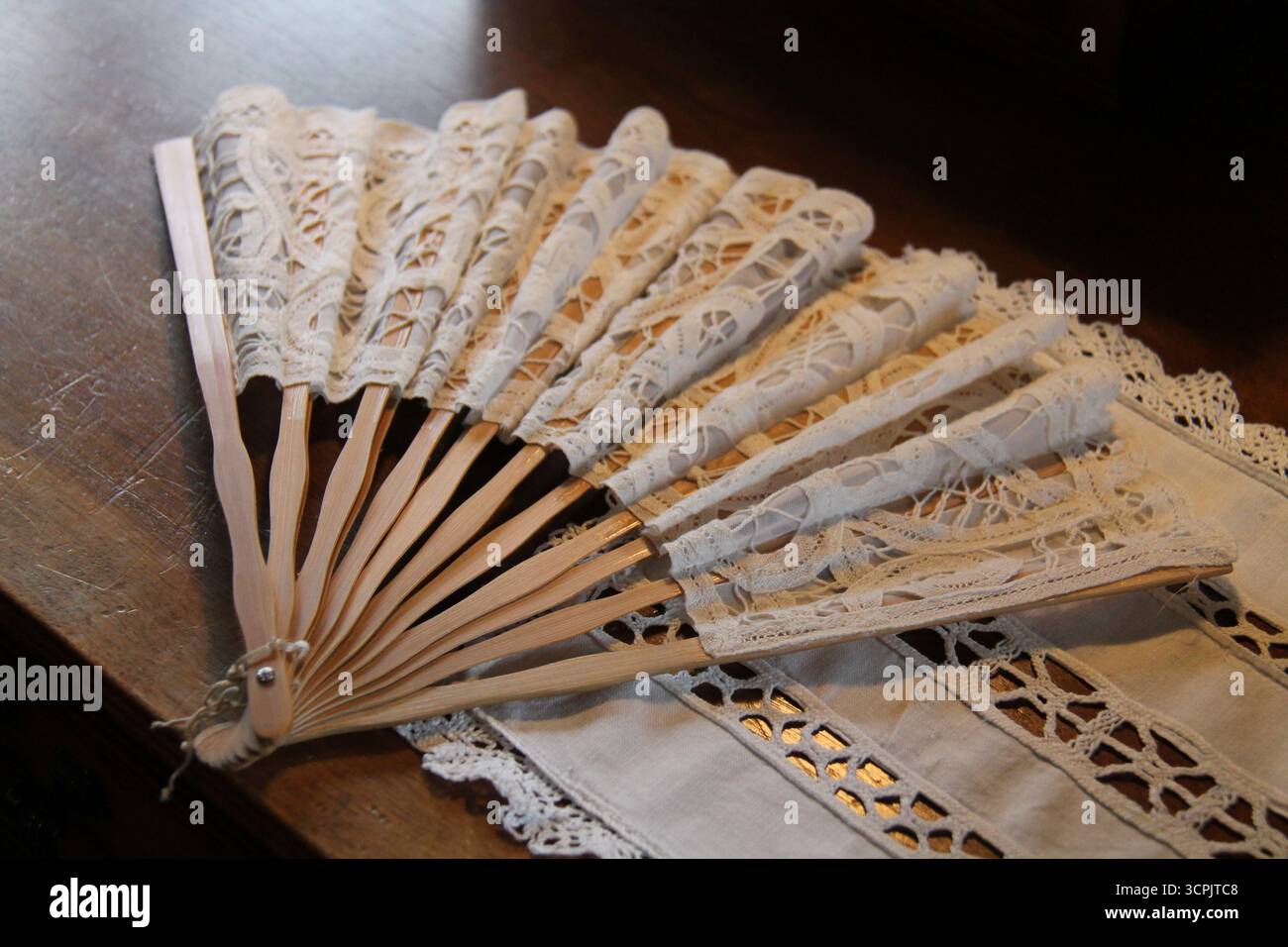 Ventilatore da donna in materiale pizzo con supporti in legno. Foto Stock