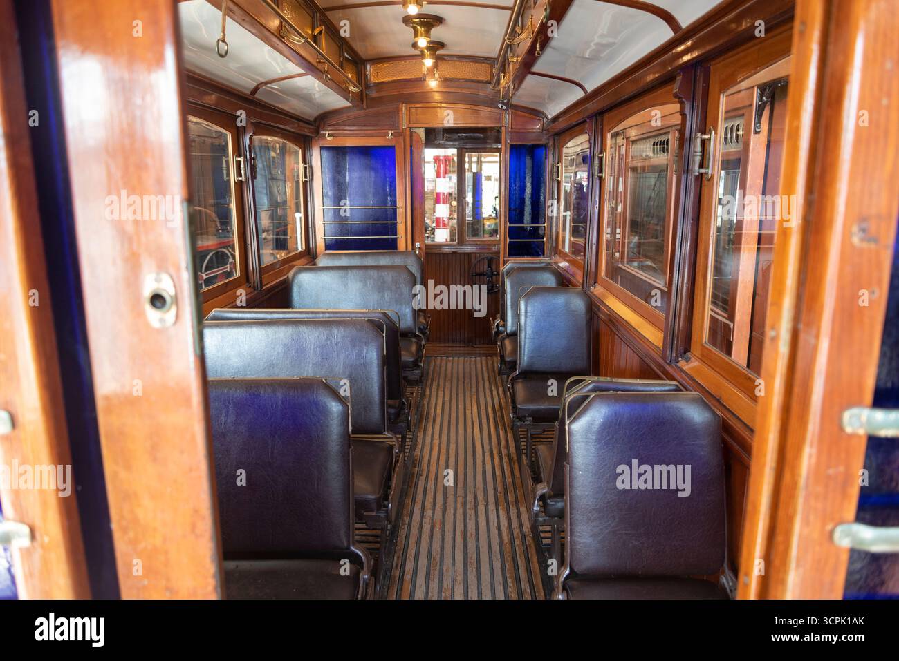 Pannelli di legno e posti a sedere vintage creano un'atmosfera invitante all'interno di questa storica carrozza ferroviaria, mettendo in risalto l'artigianato dei primi 20t. Foto Stock