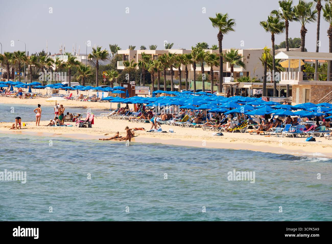 Turisti che prendono il sole e nuotano alla spiaggia di Agia Thekla, vicino a Sotira e Agia Napa, Cipro. Foto Stock