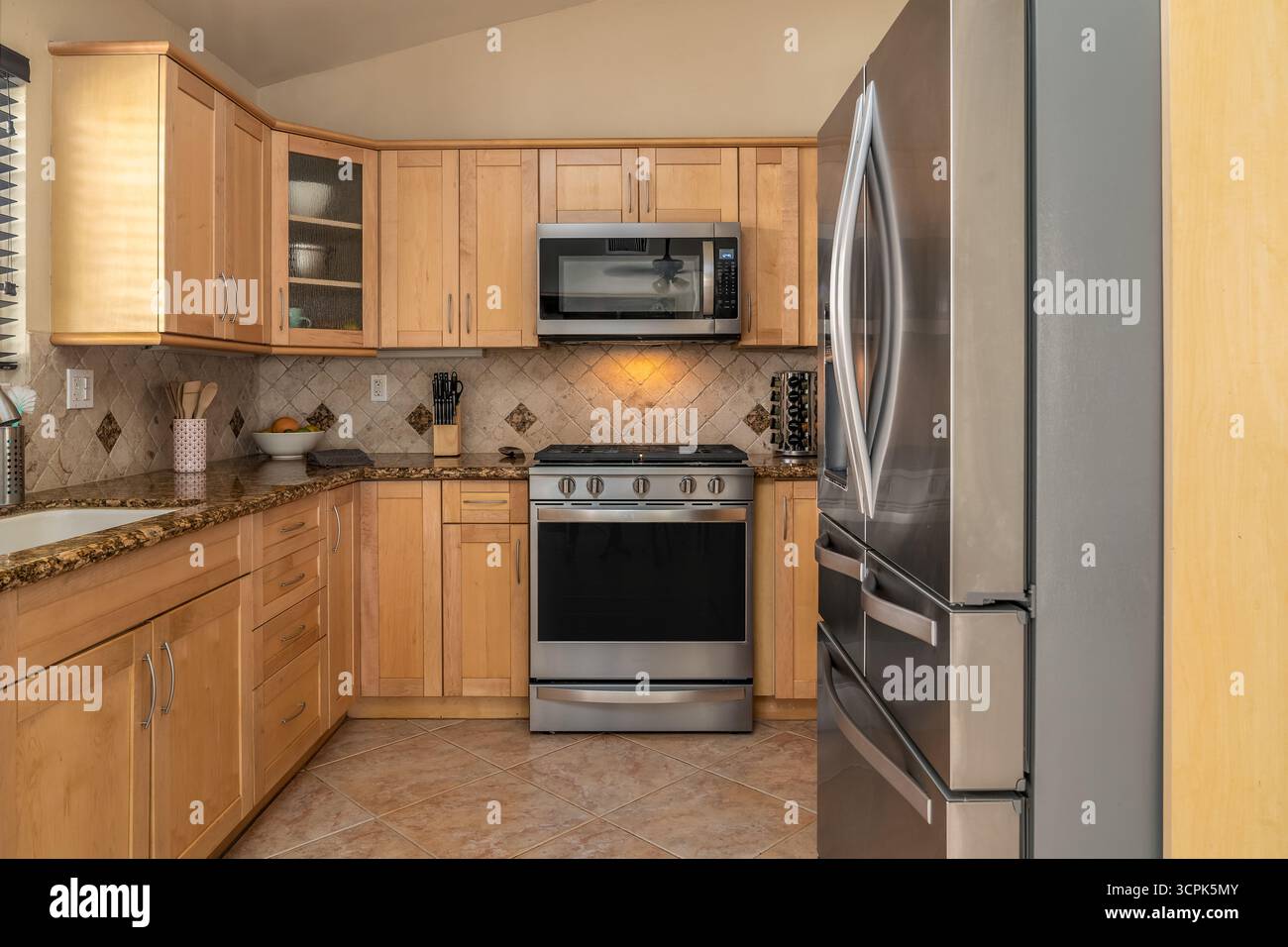 Cucina armadi in legno naturale ripiani in granito elettrodomestici in acciaio inox Foto Stock
