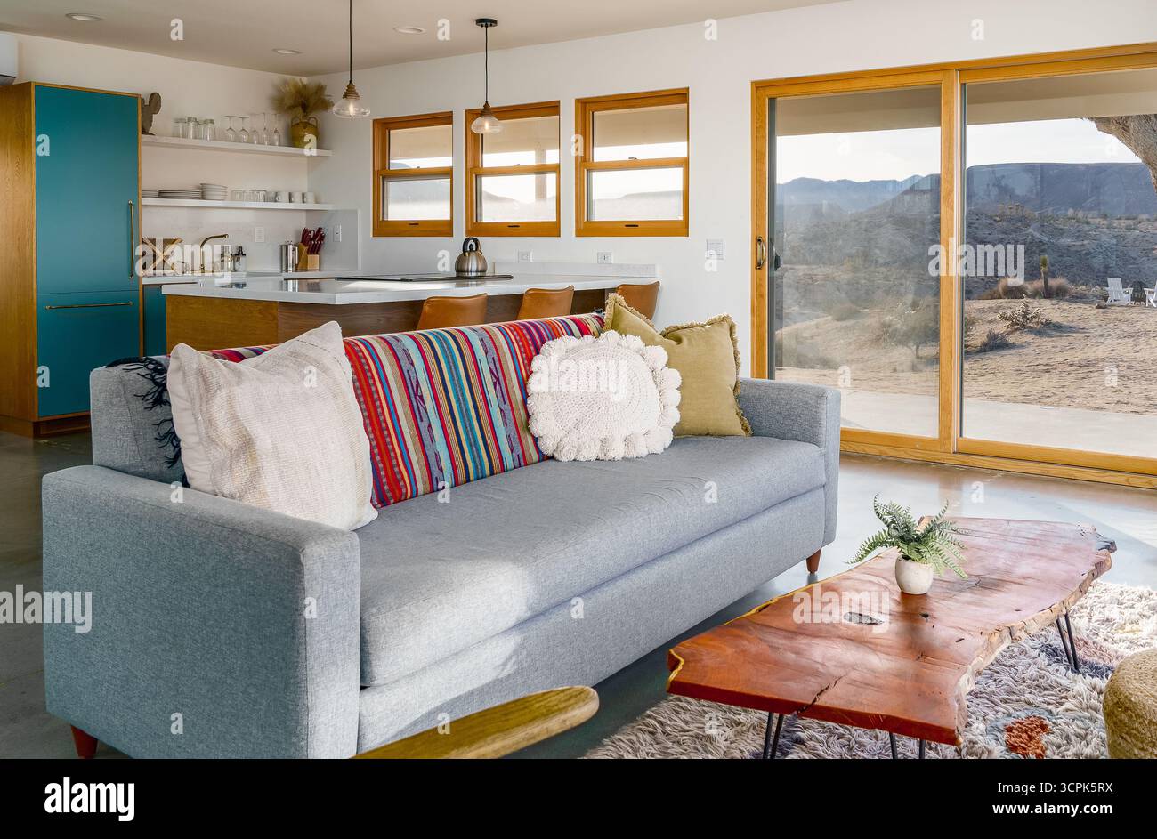 Moderno soggiorno in una casa deserta e cucina con divano a pianta aperta coperta e cuscini nella Yucca Valley california Foto Stock