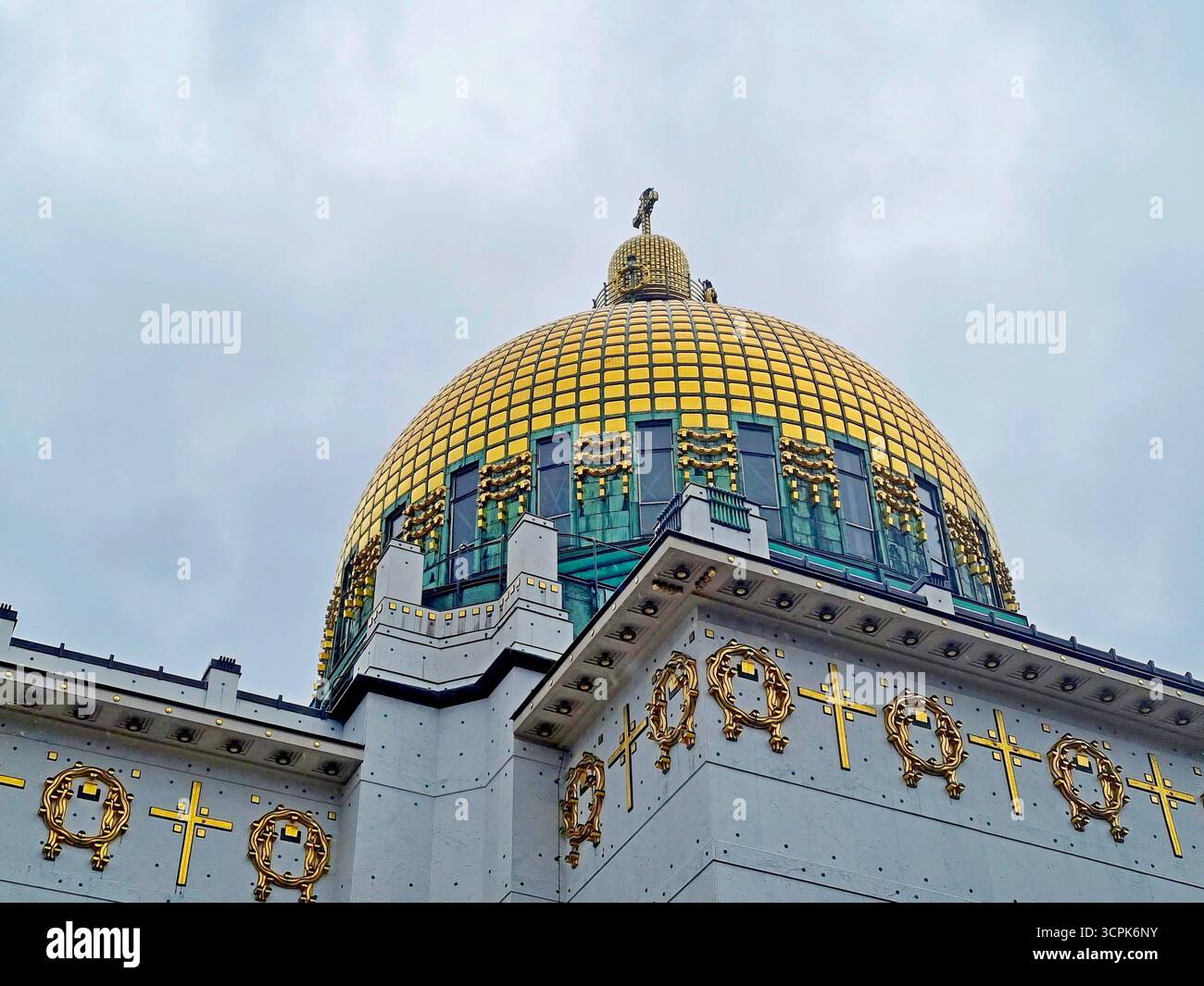 Cupola dorata della Chiesa di San Leopoldo in Art Nouveau, caratterizzata da un reticolo di piastrelle dorate sullo sfondo di ornate finestre verdi. Vienna, Austria Foto Stock