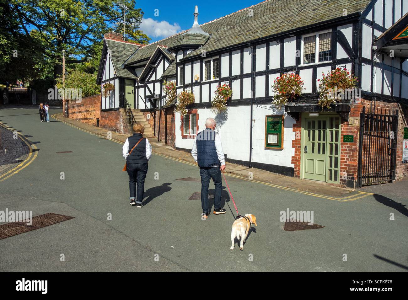 Persone che camminano davanti al pub Boat House e alla sala sul fiume nella contea del Cheshire e nella città di Chester, Inghilterra Foto Stock