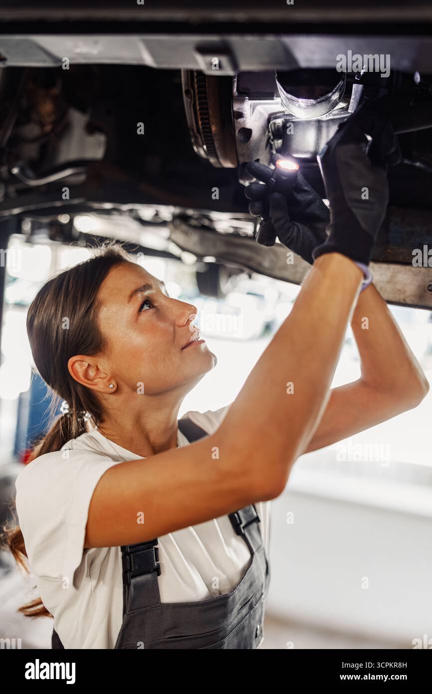Un meccanico altamente qualificato impegnato a lavorare su un veicolo automobilistico per la manutenzione Foto Stock