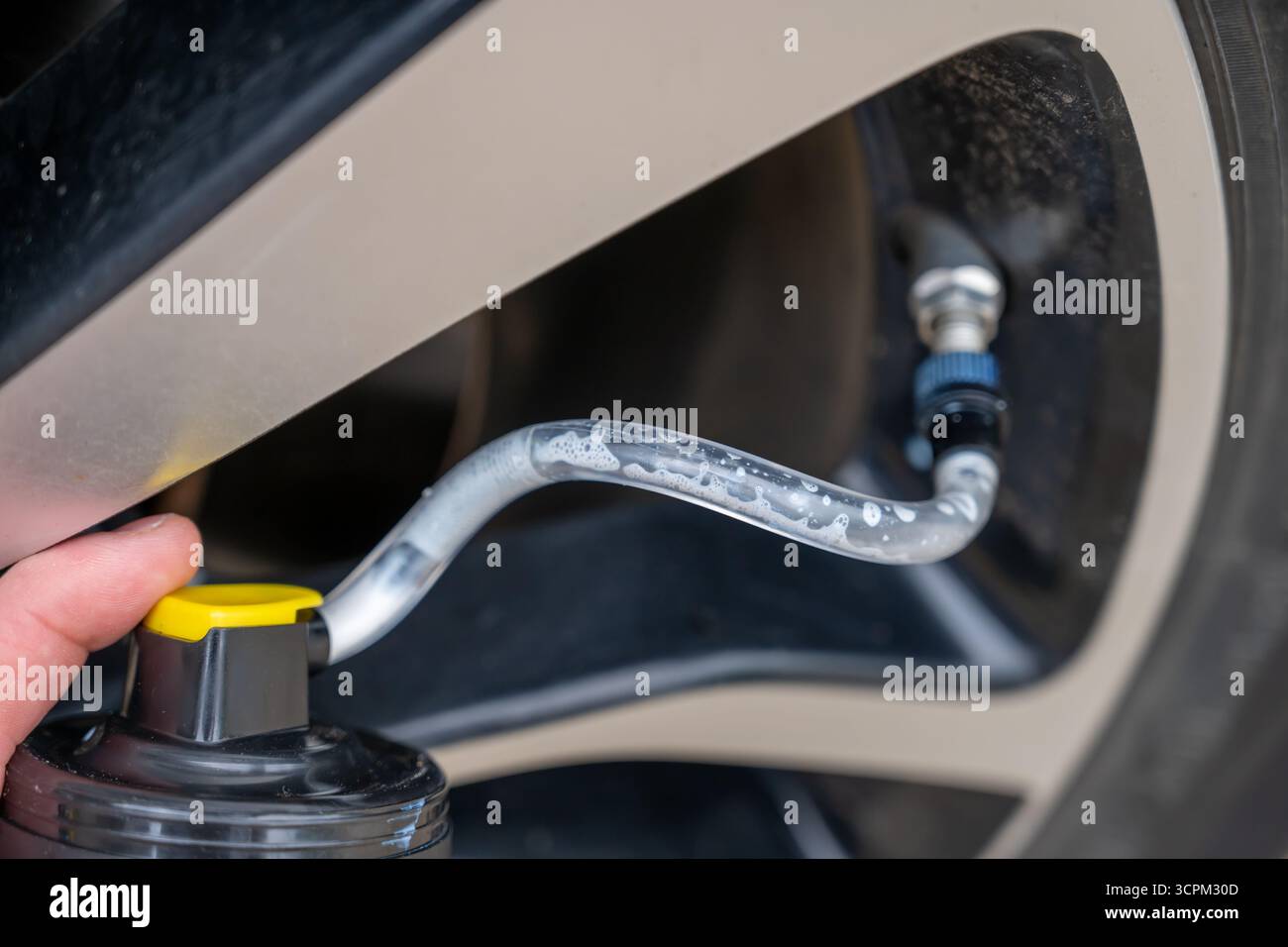Attenzione selettiva all'additivo chimico spruzzato da una lattina in uno pneumatico per riparare uno sgonfio Foto Stock