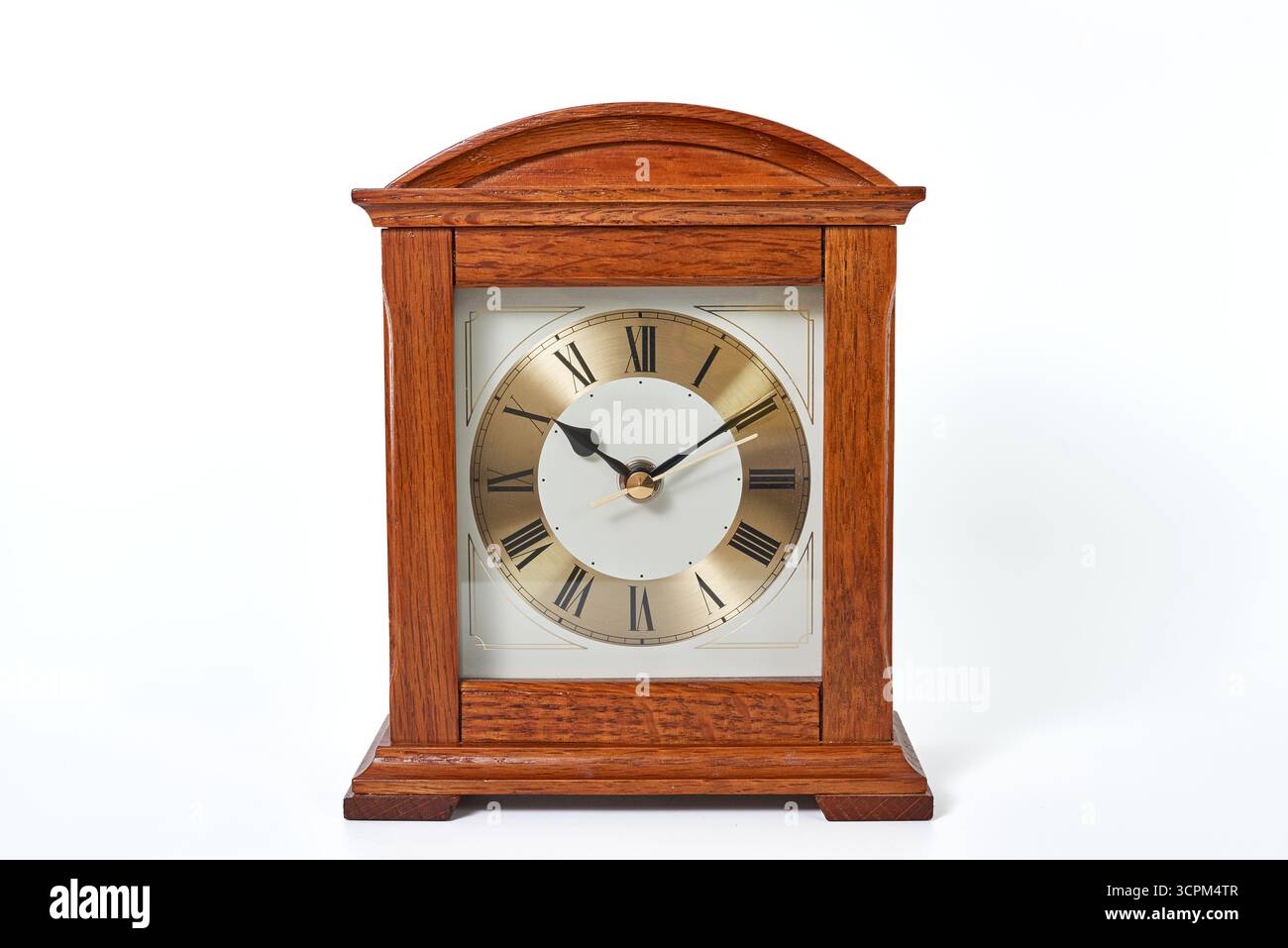 Un tradizionale orologio da scrivania quadrato con finiture in legno di quercia chiaro. Un concetto per la gestione del tempo, le scadenze dell'ufficio, la cura artigianale e l'arredamento classico per la casa Foto Stock