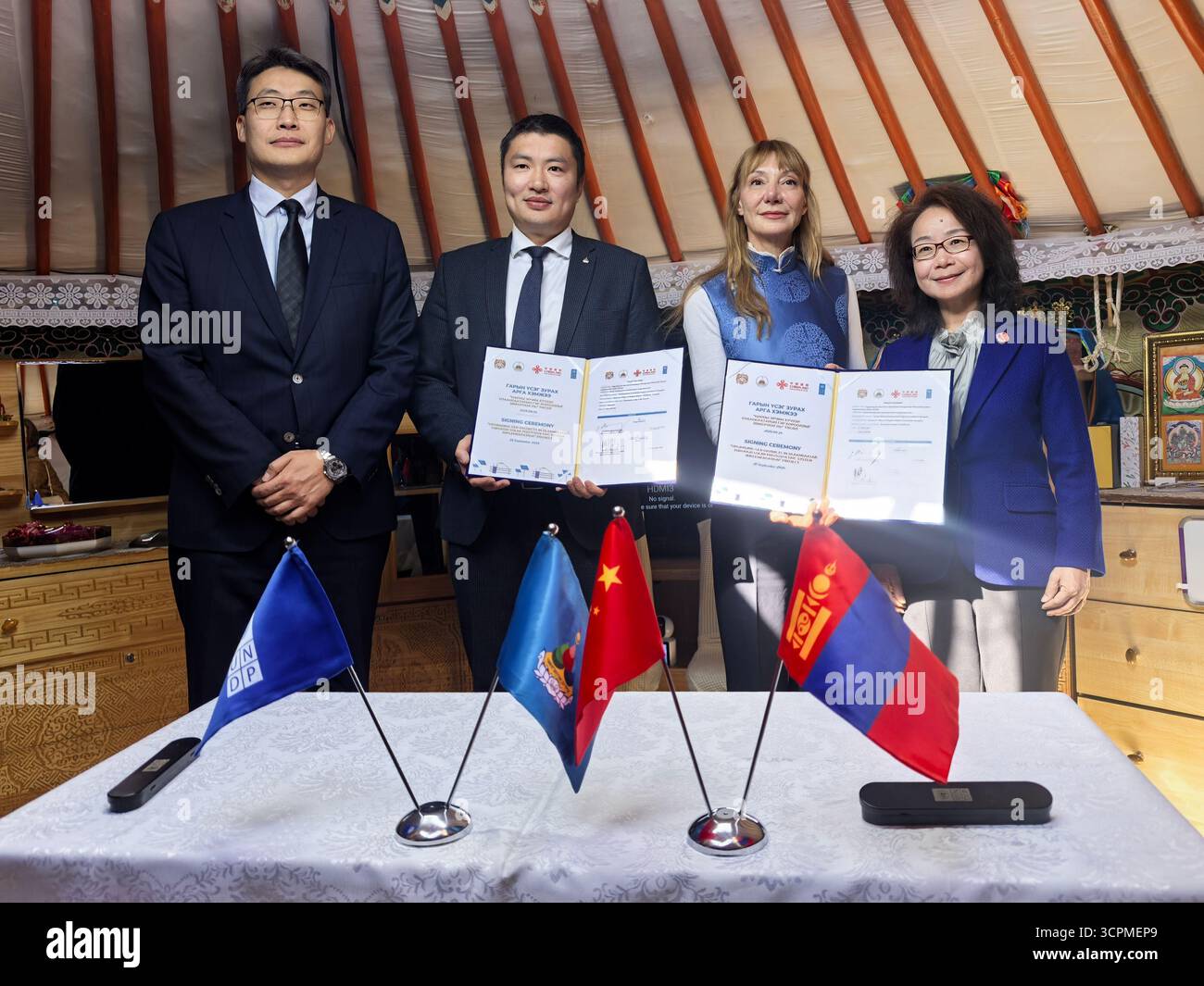 Ulan Bator, Mongolia. 25 settembre 2025. I delegati posano per le foto con contratti firmati durante una cerimonia di firma per un progetto finanziato dalla Cina nell'ambito del Global Development and South-Cooperation Fund (GDSSCF) a Ulan Bator, Mongolia, il 25 settembre 2025. L'evento si è tenuto qui giovedì, segnando il lancio di un'importante iniziativa per migliorare le aree delle baraccopoli della città, note come distretti Ger, attraverso impianti fotovoltaici solari. Crediti: Bolortsetseg/Xinhua/Alamy Live News Foto Stock