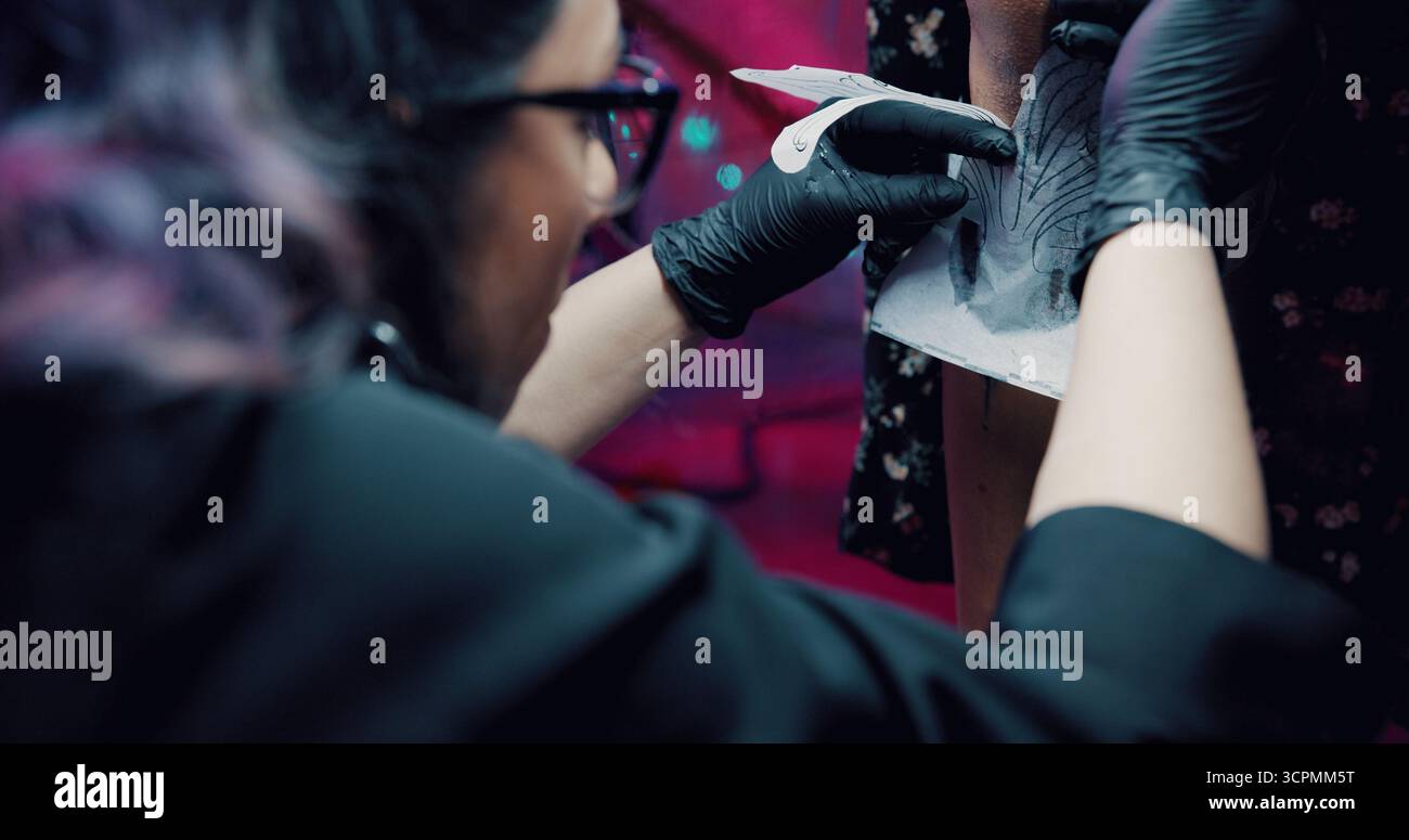 Tatuaggio, stencil e mani con l'artista in serbo per il design della body art, lo studio e la cultura. Estetica, cliente e grafica a inchiostro permanente con persone e. Foto Stock