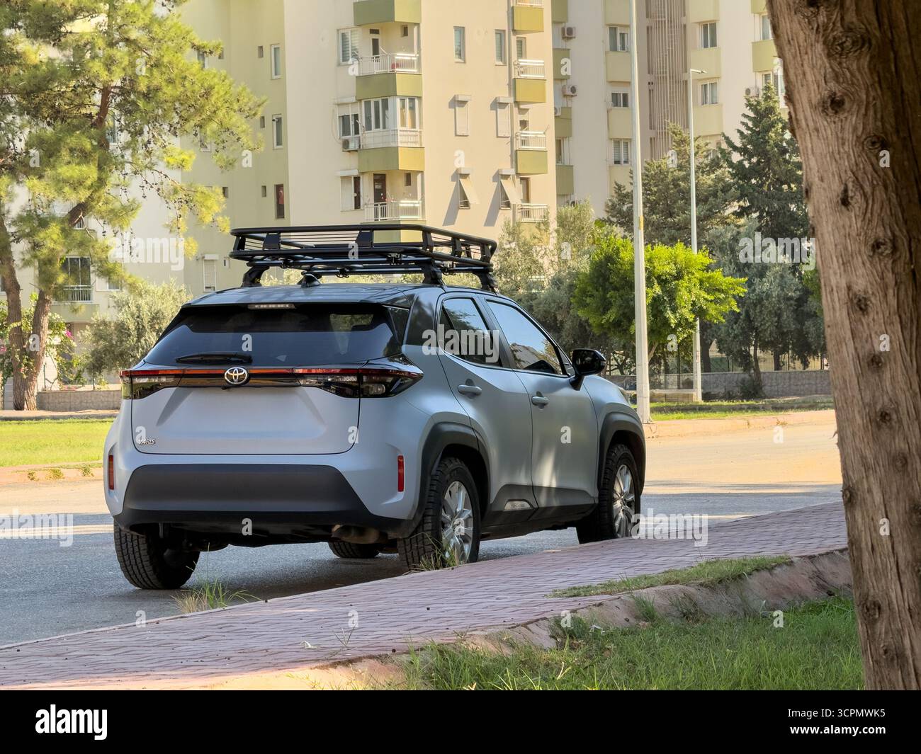 Antalya, Turchia - 26 settembre 2025: Il moderno modello SUV del marchio Toyota, Yaris Cross, è parcheggiato sul lato della strada accanto agli edifici residenziali A. Foto Stock