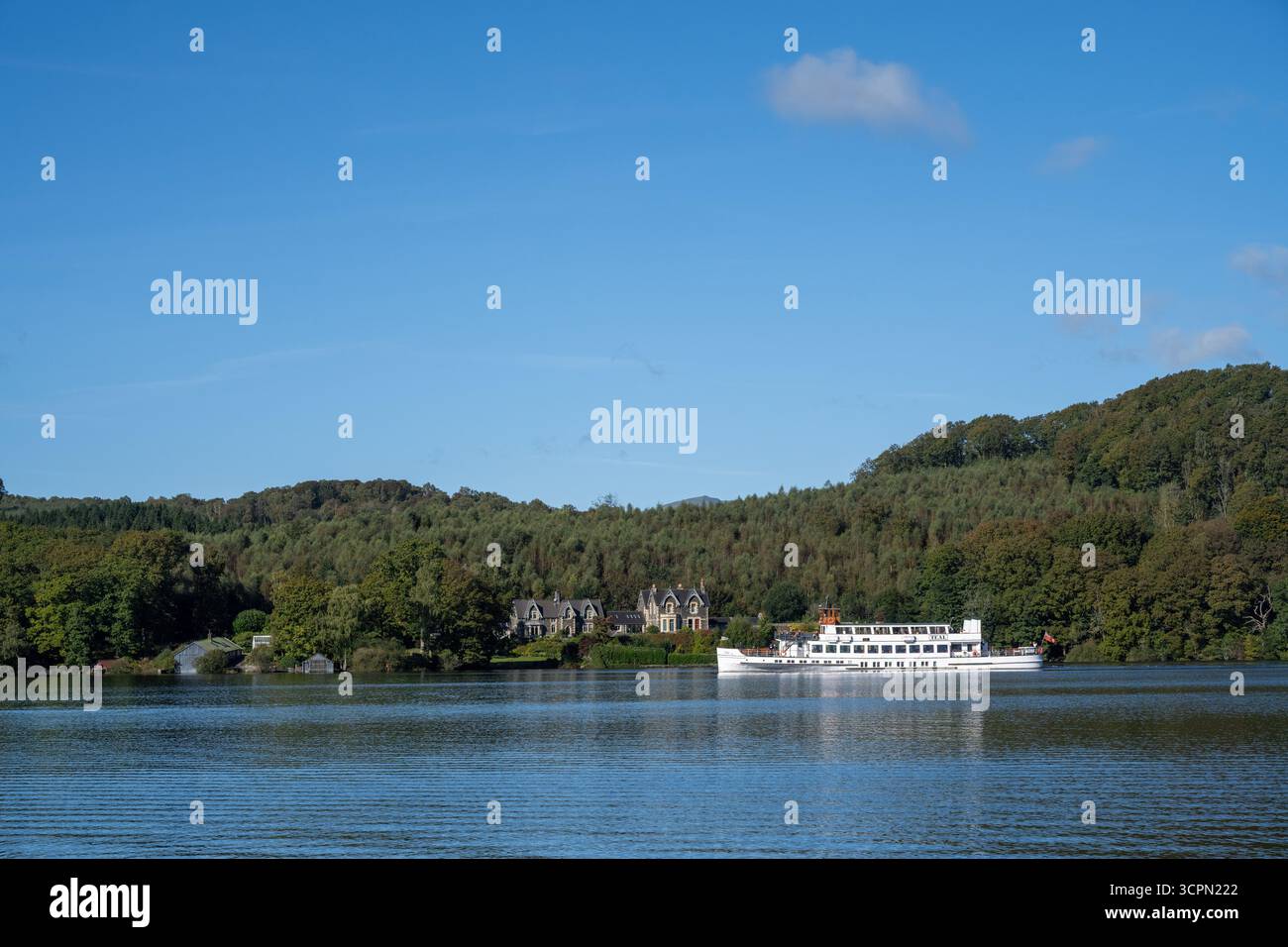Vista panoramica di Windermere con riflessi di alberi e colline lontane, Lake District National Park, Cumbria, Inghilterra Foto Stock