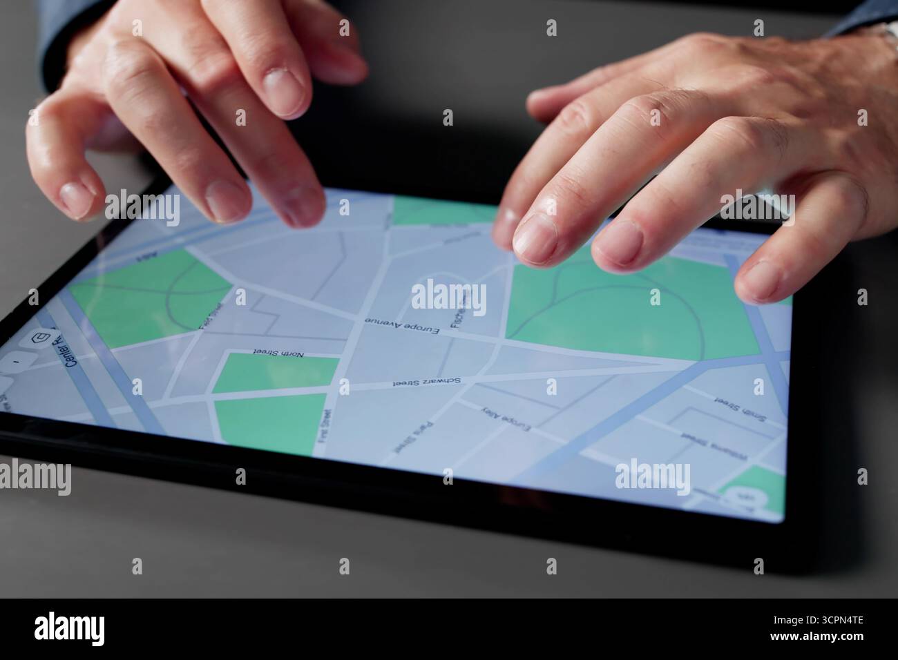 Uomo che naviga attraverso la mappa sul tablet nell'impostazione Home Office. Uomo che gestisce Un'azienda dal suo ufficio domestico Foto Stock