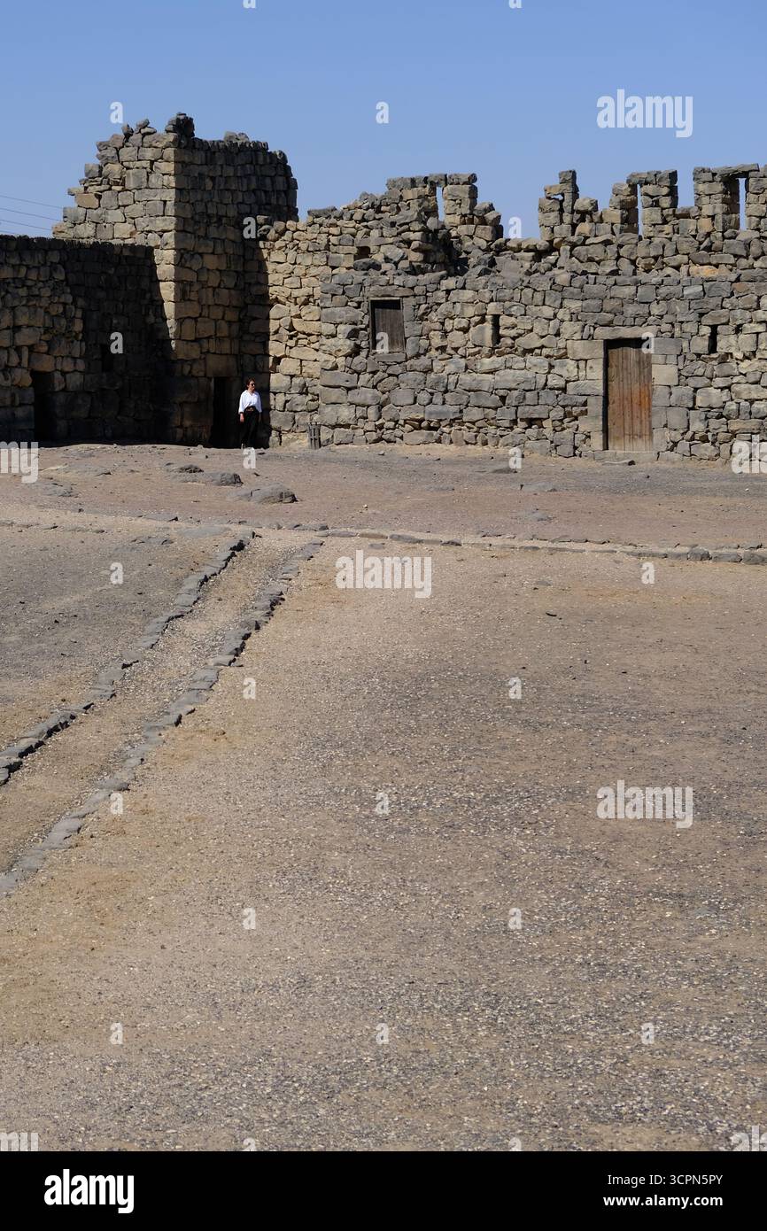 L'antico castello di Azraq (Qasr al-Azraq) sotto il sole splendente nell'arido paesaggio desertico giordano Foto Stock