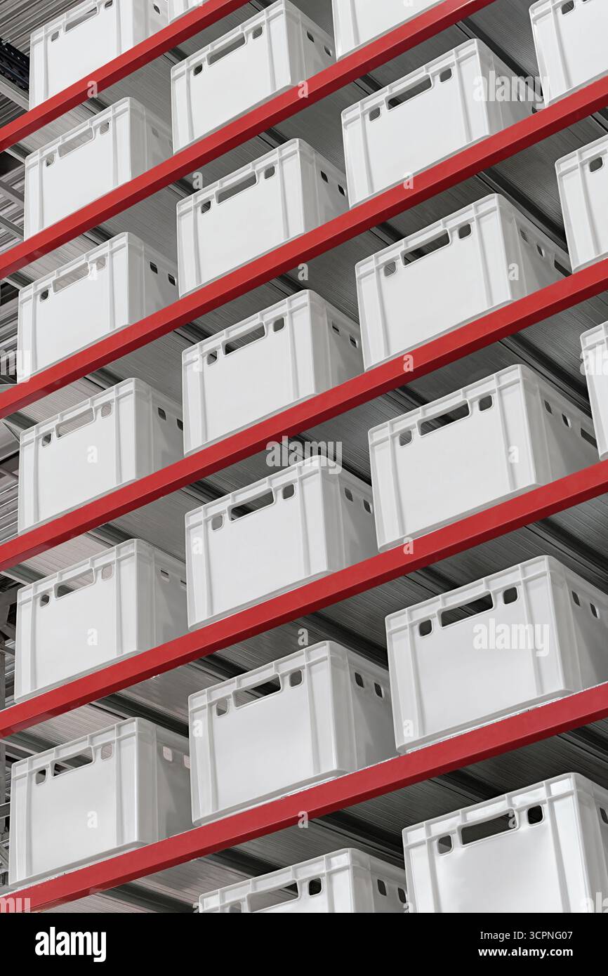 Scatole e casse bianche generiche non etichettate sugli scaffali di un rack da magazzino, sfondo industriale astratto Foto Stock