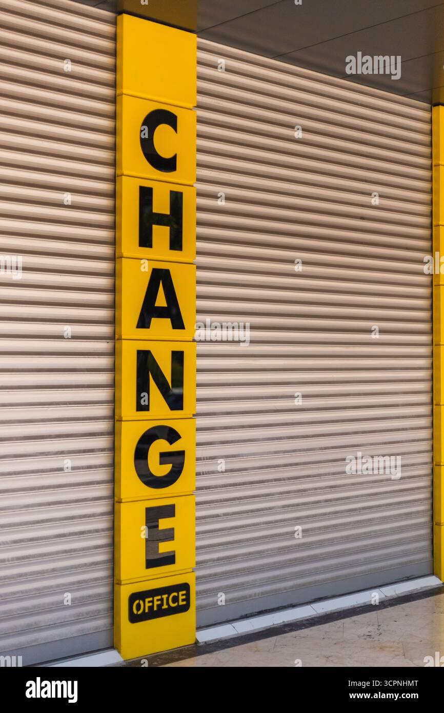 Un ufficio di cambio marcia è visto con lettere in grassetto sul cartello, mentre le sue persiane sono chiuse. I colori giallo brillante e nero attirano l'attenzione sul Foto Stock