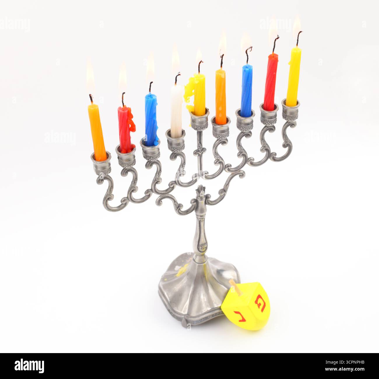 Le candele di Hanukkah bruciano di dreidel, isolate sul bianco Foto Stock