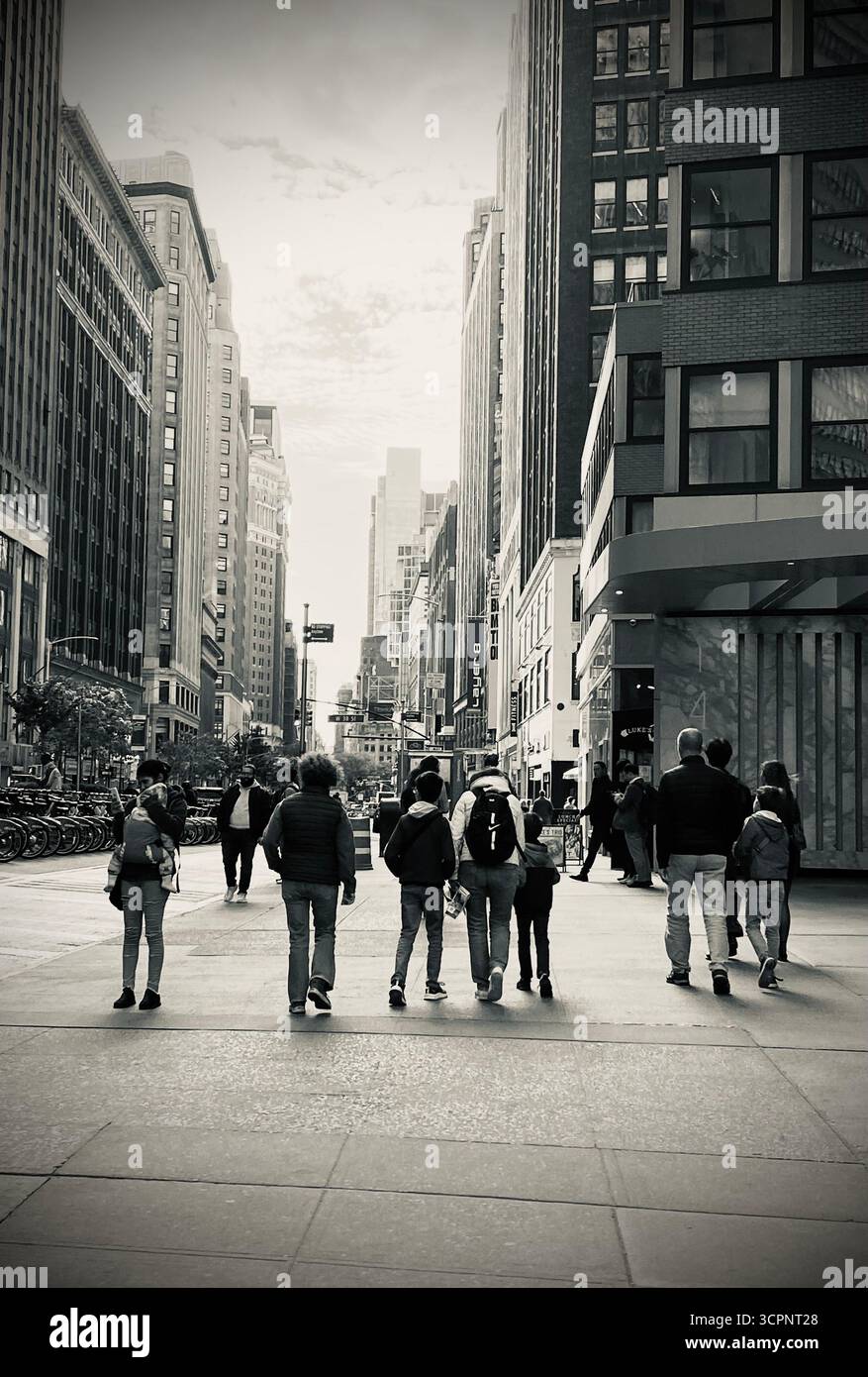 Black and White Urban Street Scene con pedoni ed edifici alti Foto Stock