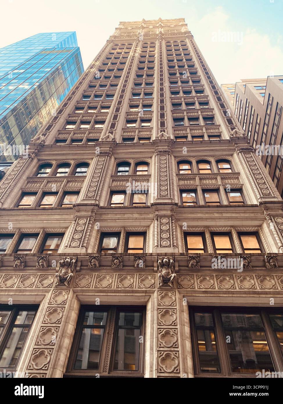 Grattacielo neogotico con facciata decorata vista da Low Angle sotto il cielo blu - Immagine stock catturata con smartphone