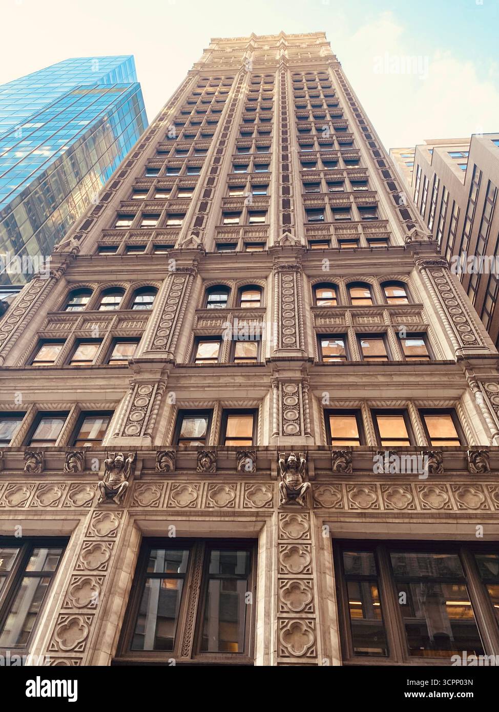 Grattacielo neogotico con facciata decorata vista da Low Angle sotto il cielo blu Foto Stock