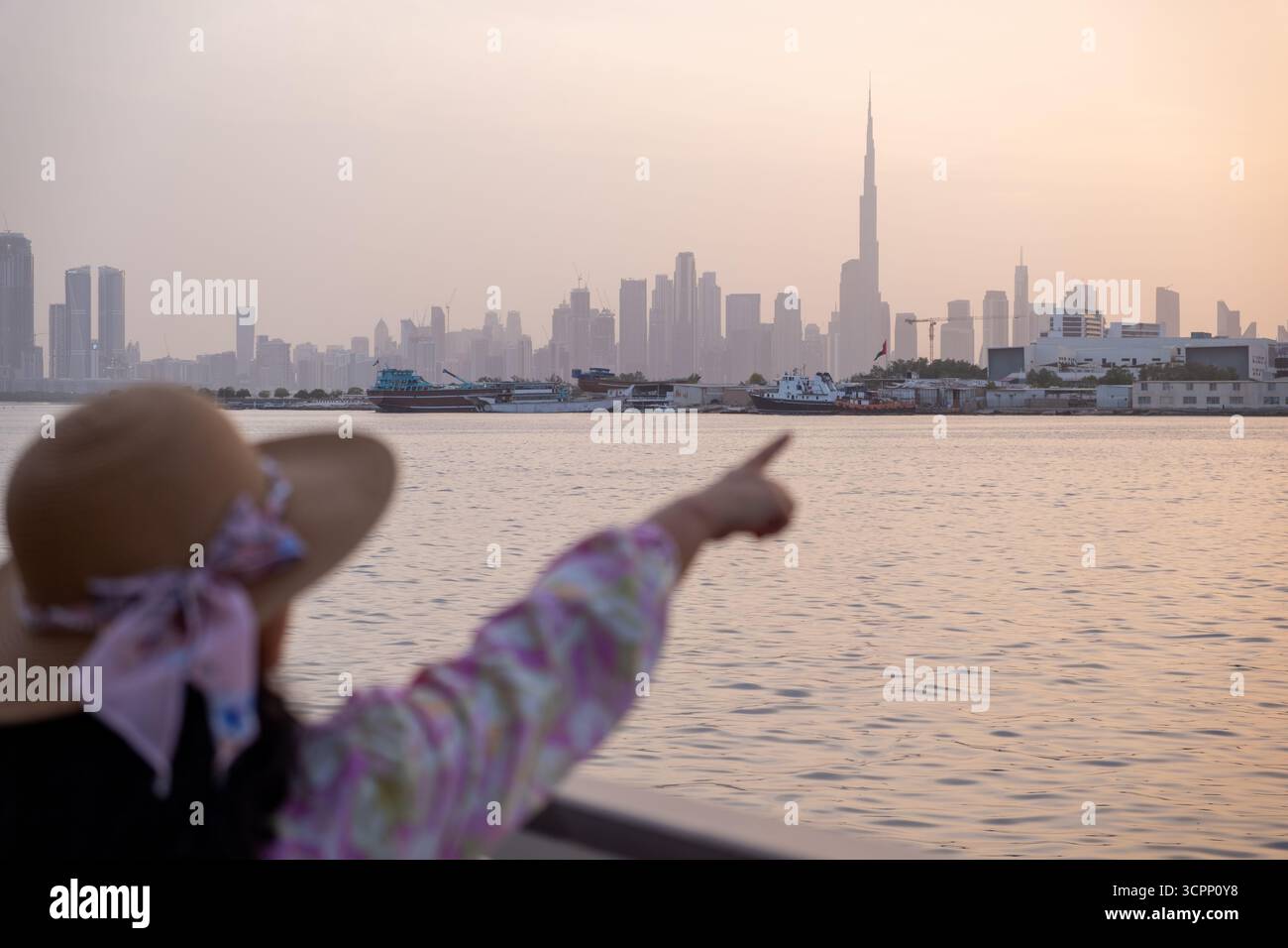 Un turista che indica l'iconico skyline di Burj Khalifa al tramonto, il viaggio a Dubai e lo stile di vita di lusso Foto Stock