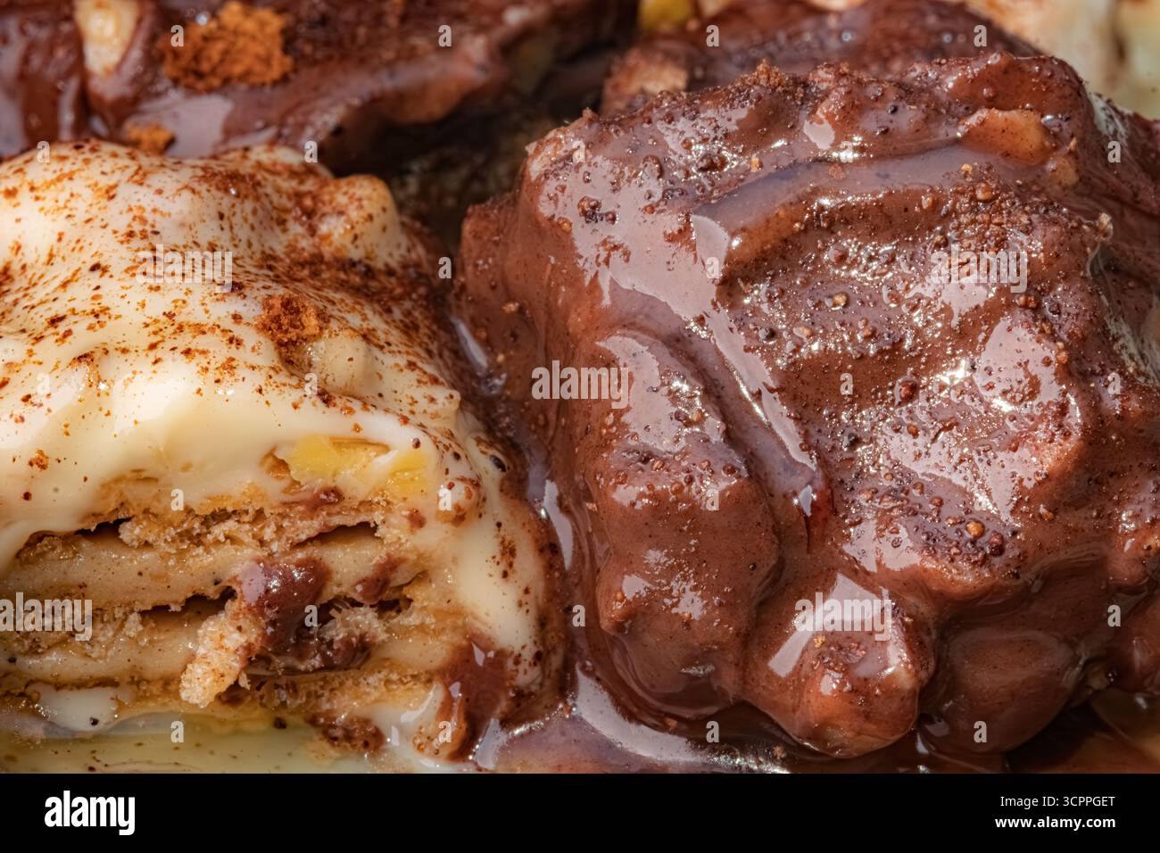 Dolcetti cremosi con strati di cioccolato e biscotti. Makro shot di due distinti dessert turchi a base di latte, uno con strati di biscotti. Foto Stock