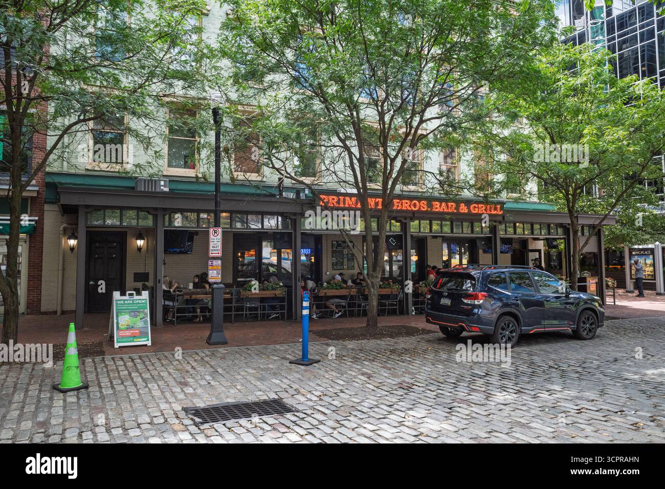 Gli iconici Primanti Bros Bar & Grill a Pittsburgh, Pennsylvania, con un SUV blu scuro parcheggiato sulla storica strada acciottolata. Foto Stock