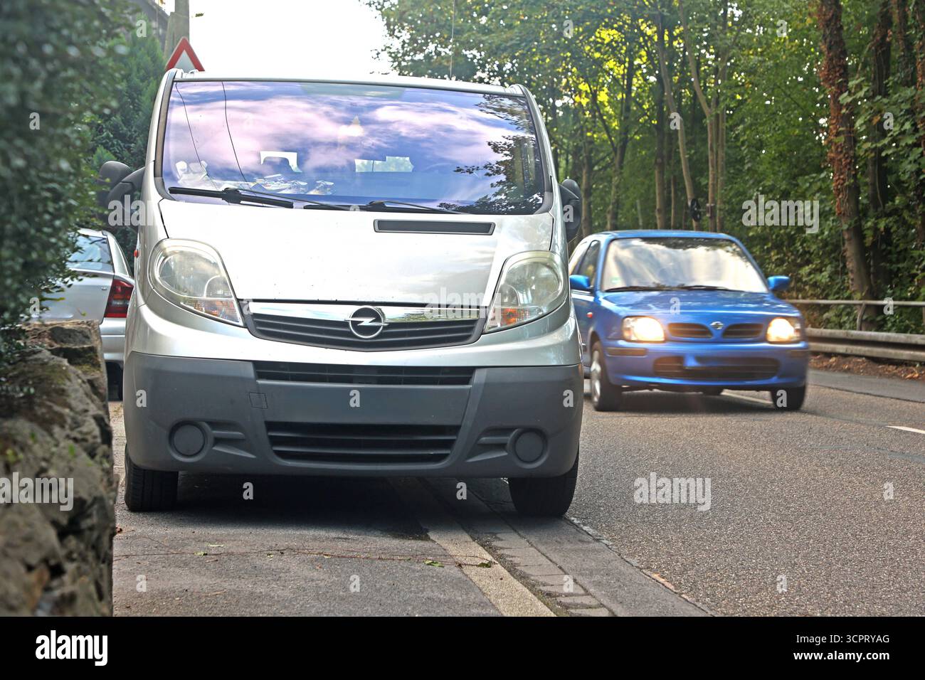 Falschparker in der Stadt Ein falsch geparkter Transporter blockiert nahezu vollständig einen Bürgersteig für Fußgänger *** veicoli parcheggiati illegalmente in città un furgone non correttamente parcheggiato blocca quasi completamente un marciapiede per i pedoni Foto Stock