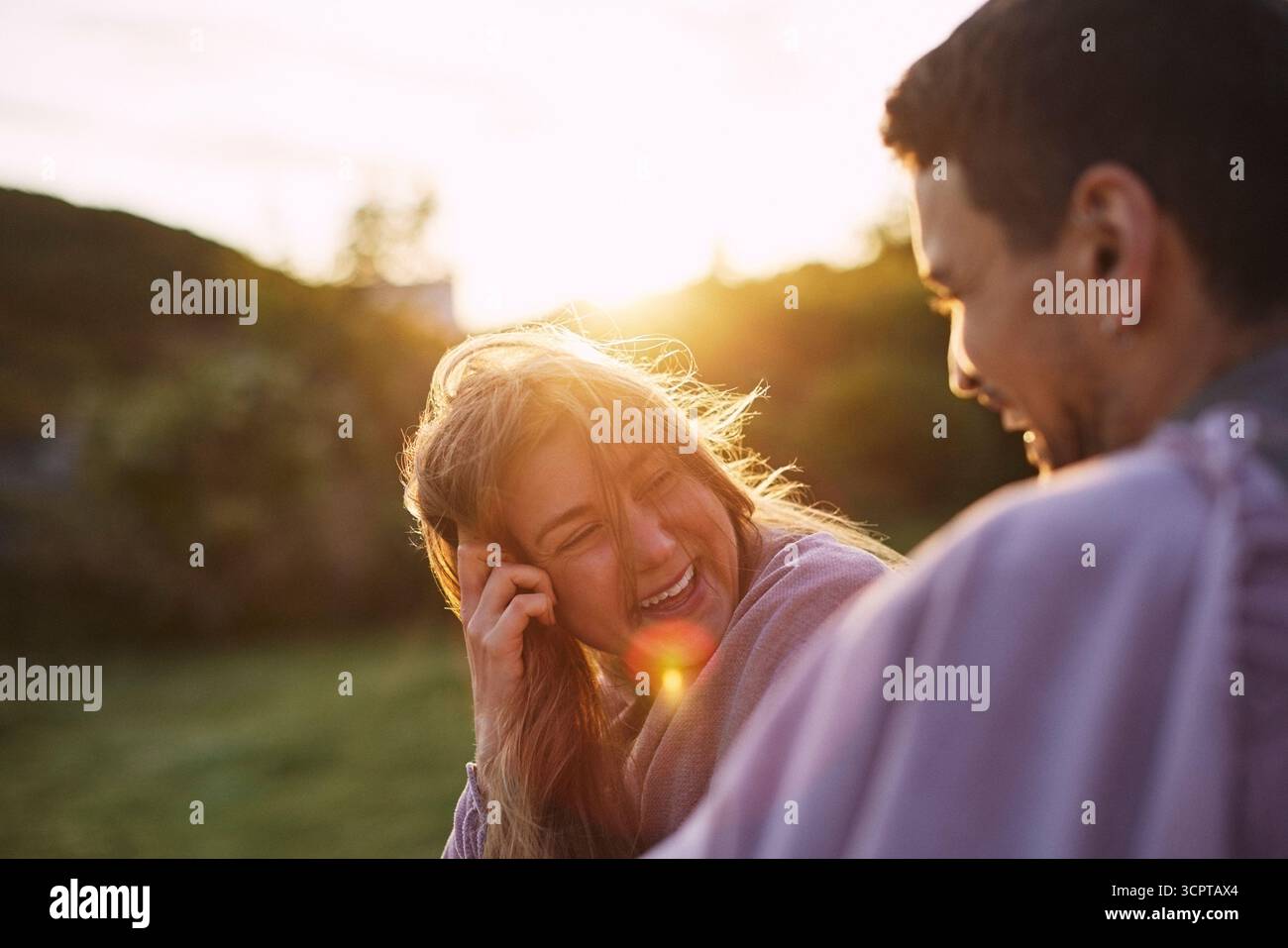 La luce del sole splende sulla donna felice che si diverte con il fidanzato durante le vacanze estive Foto Stock