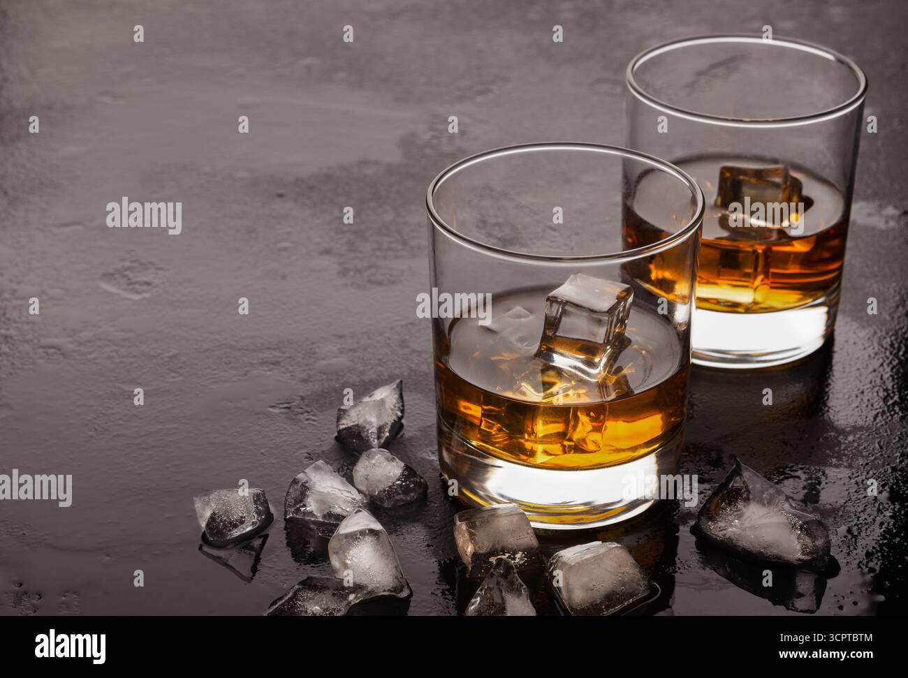 Due bicchieri di whiskey e ghiaccio su sfondo nero Foto Stock