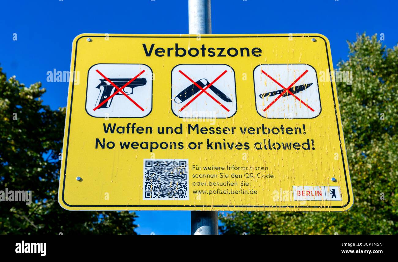 Primo piano di una zona di divieto di armi vandalizzate (Waffenverbotszone) a Kreuzberg che mostra restrizioni contro armi e coltelli. Foto Stock