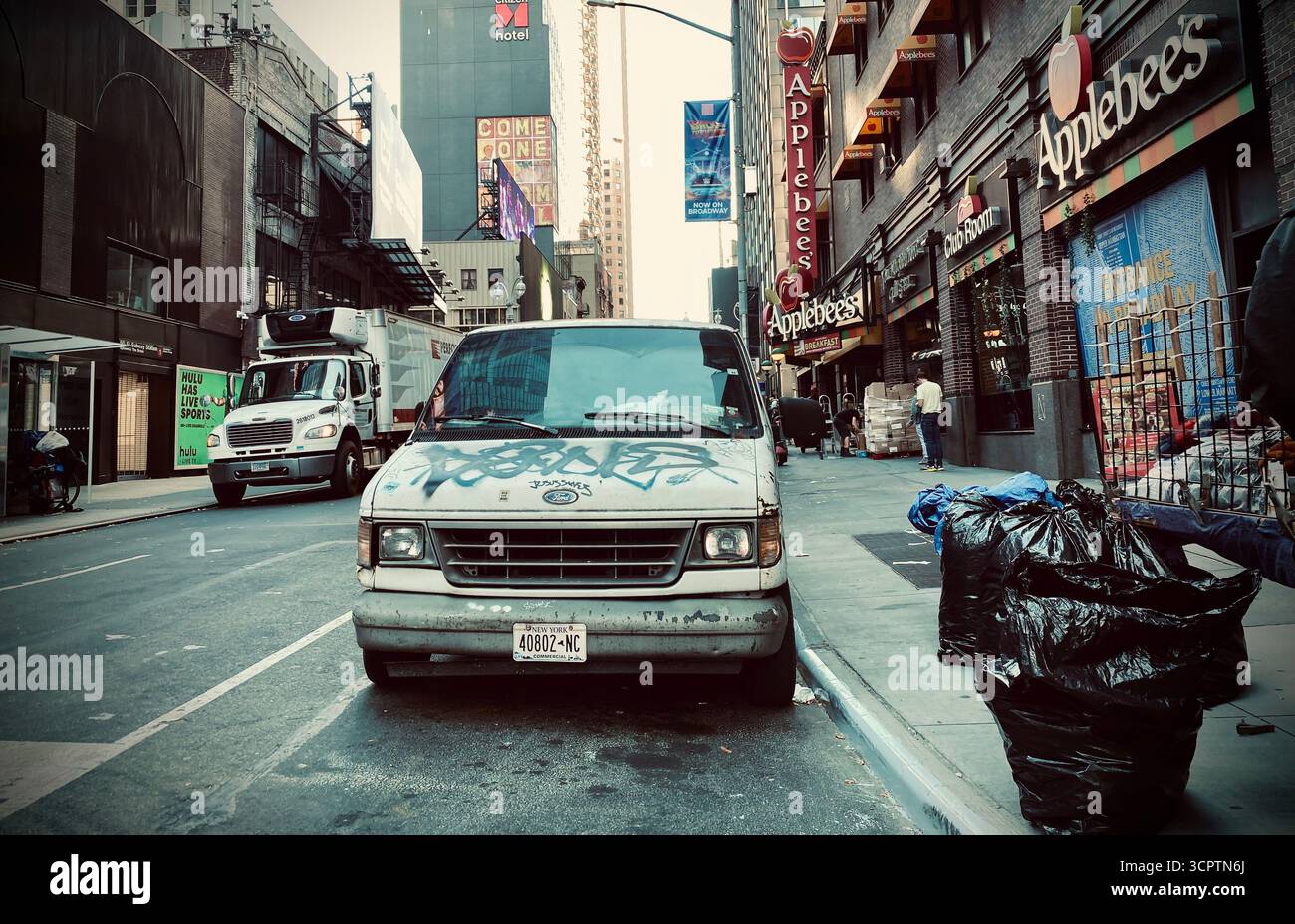 Ford Van è stata incisa con graffiti sulla trafficata New York Street con Applebee's e Urban Details Foto Stock