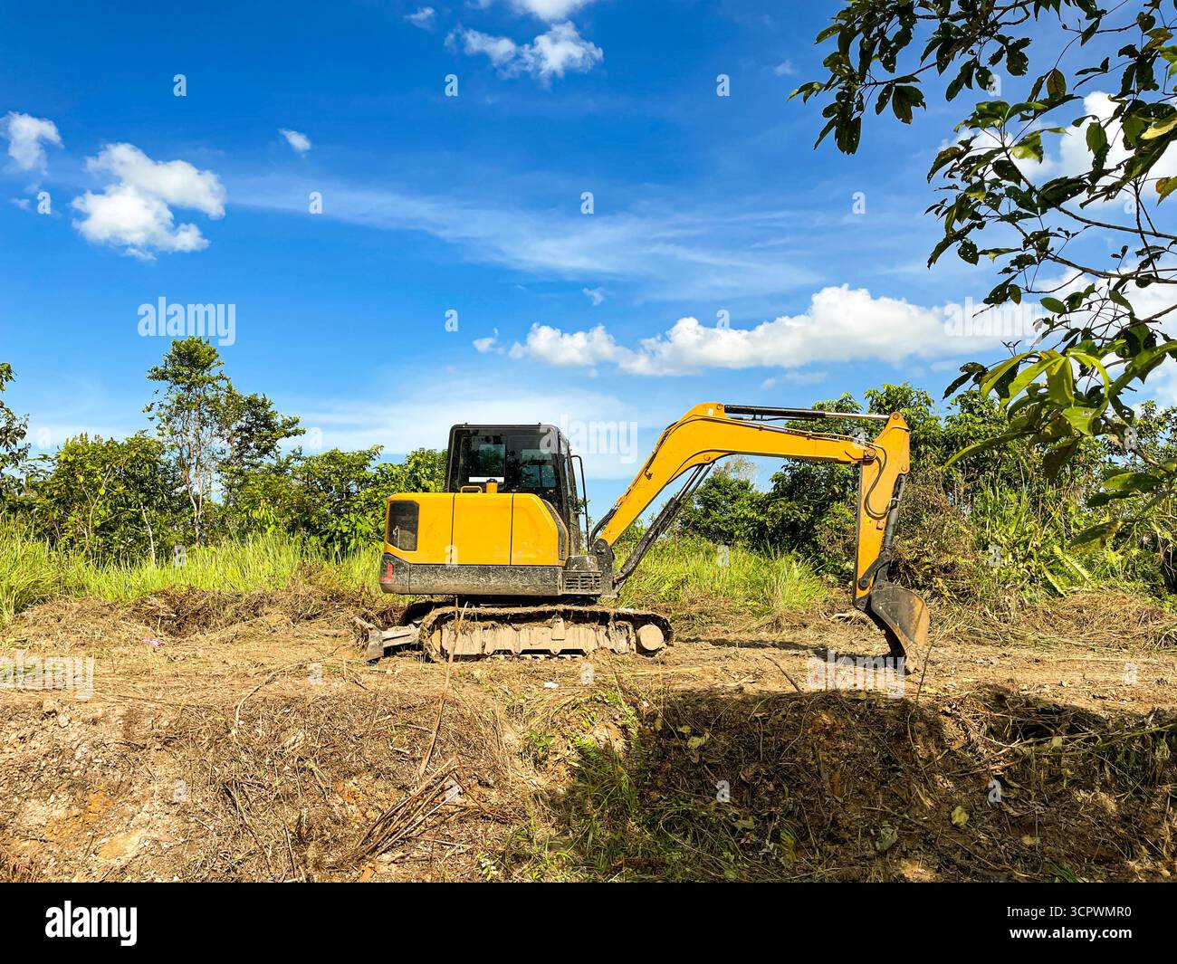 L'escavatore con benna sollevata sta scavando il terreno nel cantiere - Immagine stock catturata con smartphone