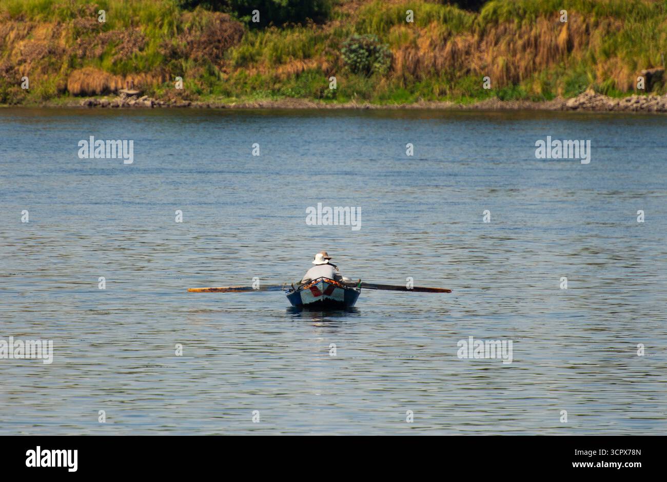 Tradizionale beduino egiziano pescatore in barca a remi sul fiume Nilo Pesca da riva Foto Stock