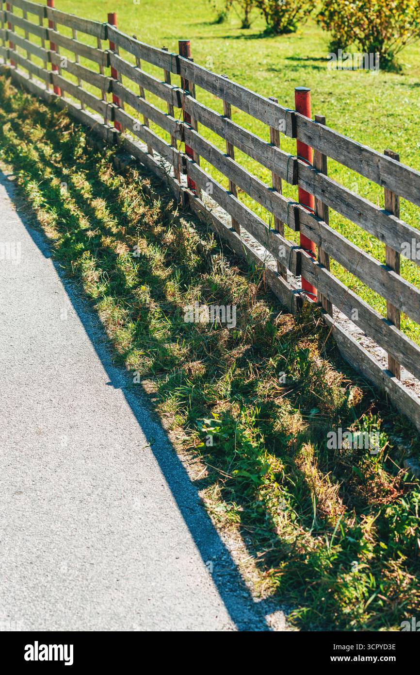 Recinzione rurale con palo in metallo e tavole di legno nel paesaggio paesaggistico sloveno. Messa a fuoco selettiva. Foto Stock