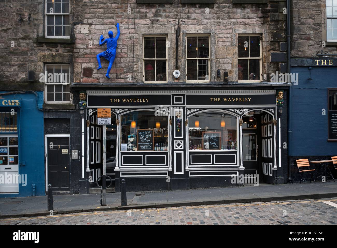 Figura di un "uomo blu" che sale sulla parete del bar Waverley in St Mary's Street, Edimburgo, Scozia, Regno Unito. Foto Stock