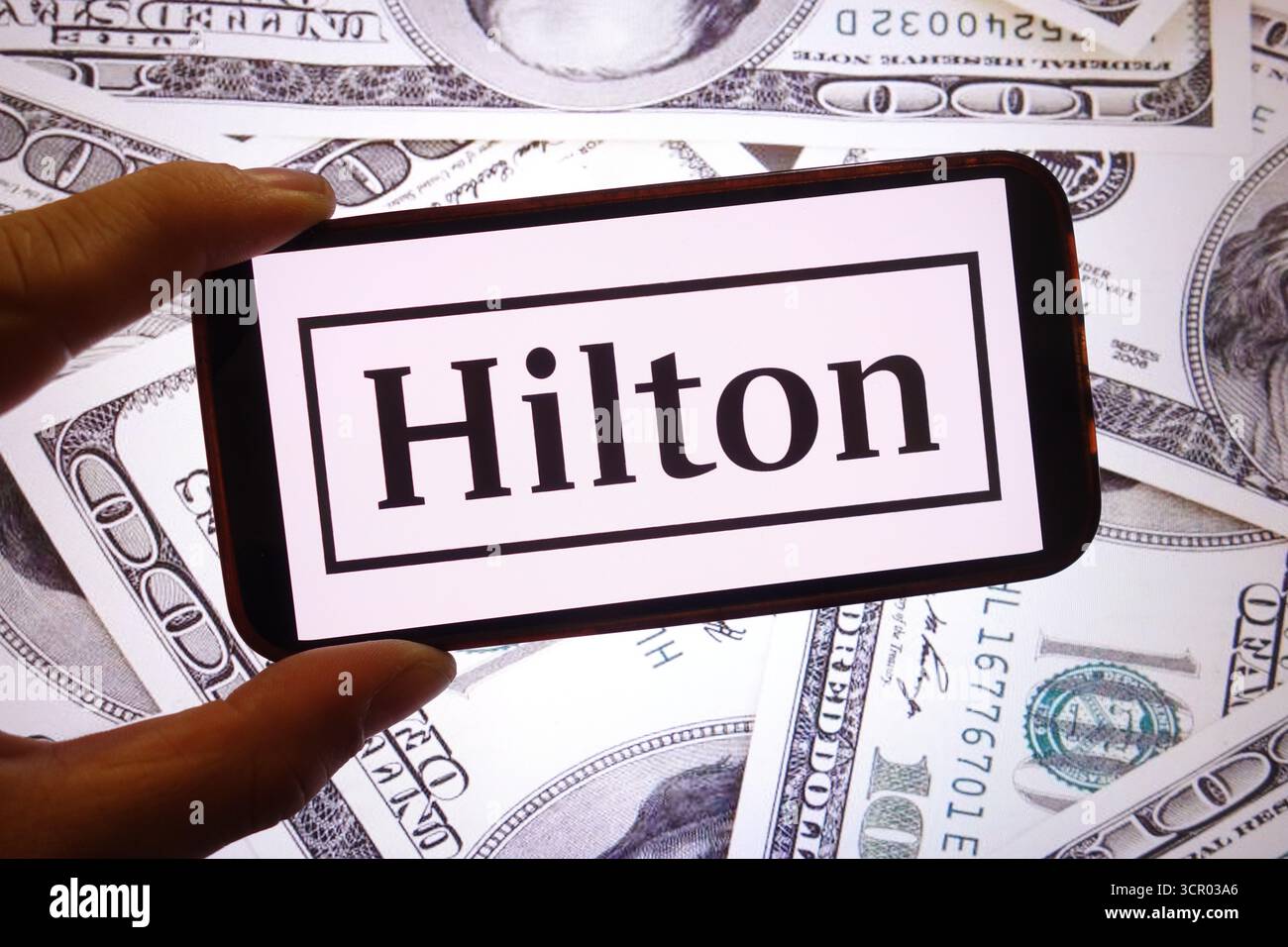 In questa immagine, il logo della società Hilton Worldwide è visualizzato sullo schermo di uno smartphone. Foto Stock