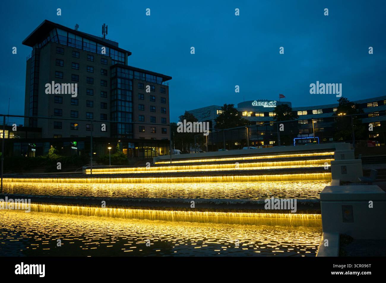 Immagine notturna di un moderno campus per uffici con giochi d'acqua, facciate in vetro nel paesaggio urbano, Zoetermeer, Paesi Bassi. Qui ha sede la compagnia idrica Dunea. Foto Stock