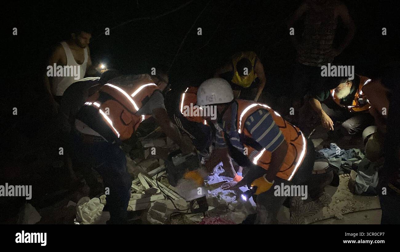 Gaza, Gaza. 28 settembre 2025. Gli equipaggi della difesa civile palestinese lavorano per salvare le vittime in un sito colpito dai bombardamenti israeliani nella città di Gaza domenica 28 settembre 2025. Foto di difesa civile palestinese/UPI credito: UPI/Alamy Live News Foto Stock