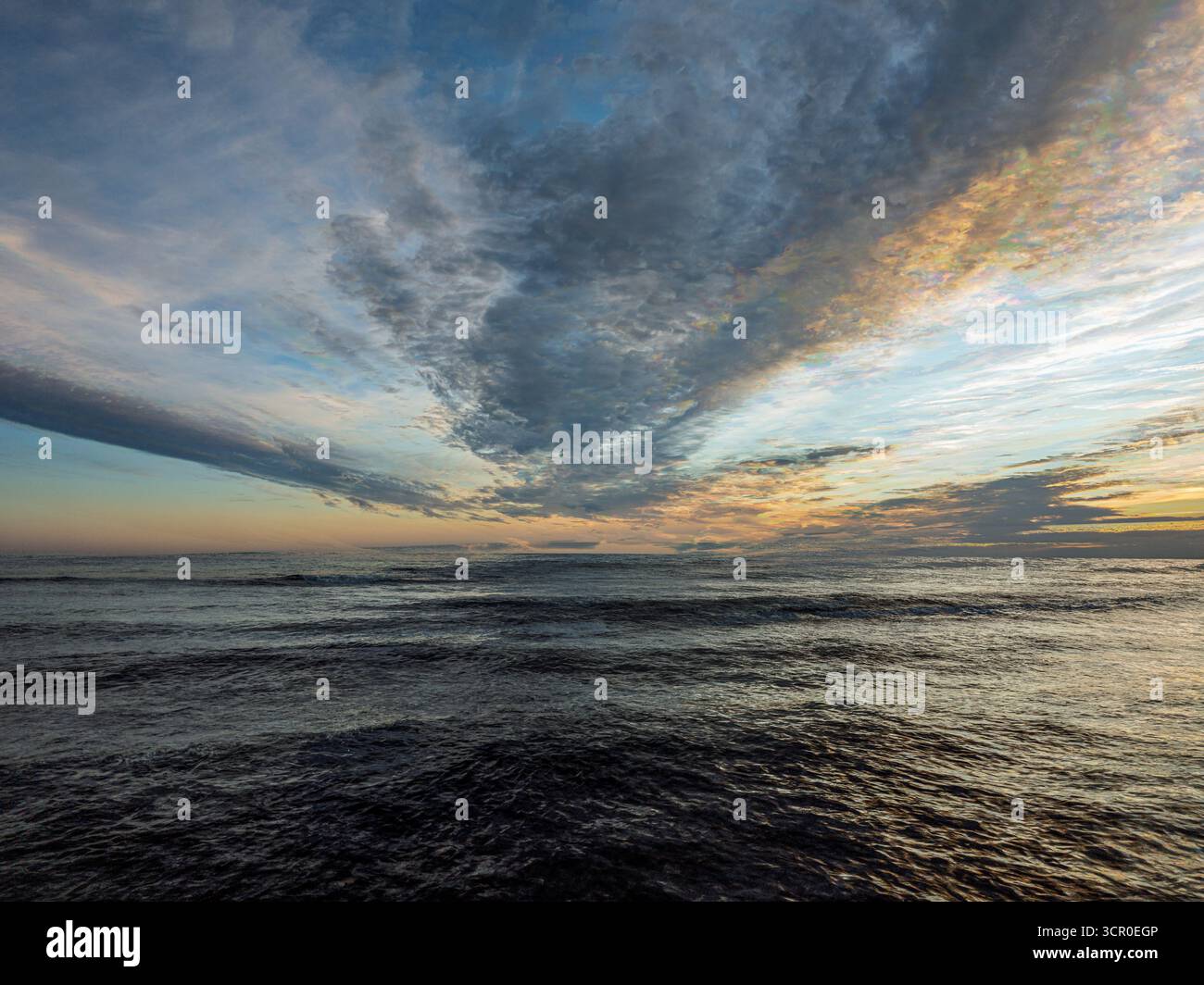 La lunga esposizione cattura la calma Oceano Atlantico al tramonto, mettendo in evidenza i colori e le formazioni nuvolose mozzafiato sopra Huelva, Spagna. Foto Stock